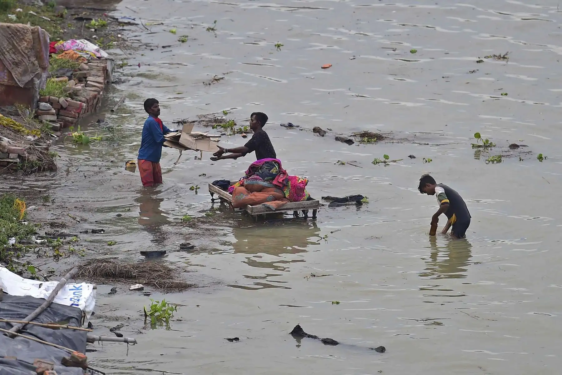 Los residentes afectados por las inundaciones de un área baja trasladan sus pertenencias en un carro de mano a un lugar más seguro a orillas del río Ganges luego de las fuertes lluvias monzónicas en Allahabad . Foto: AFP