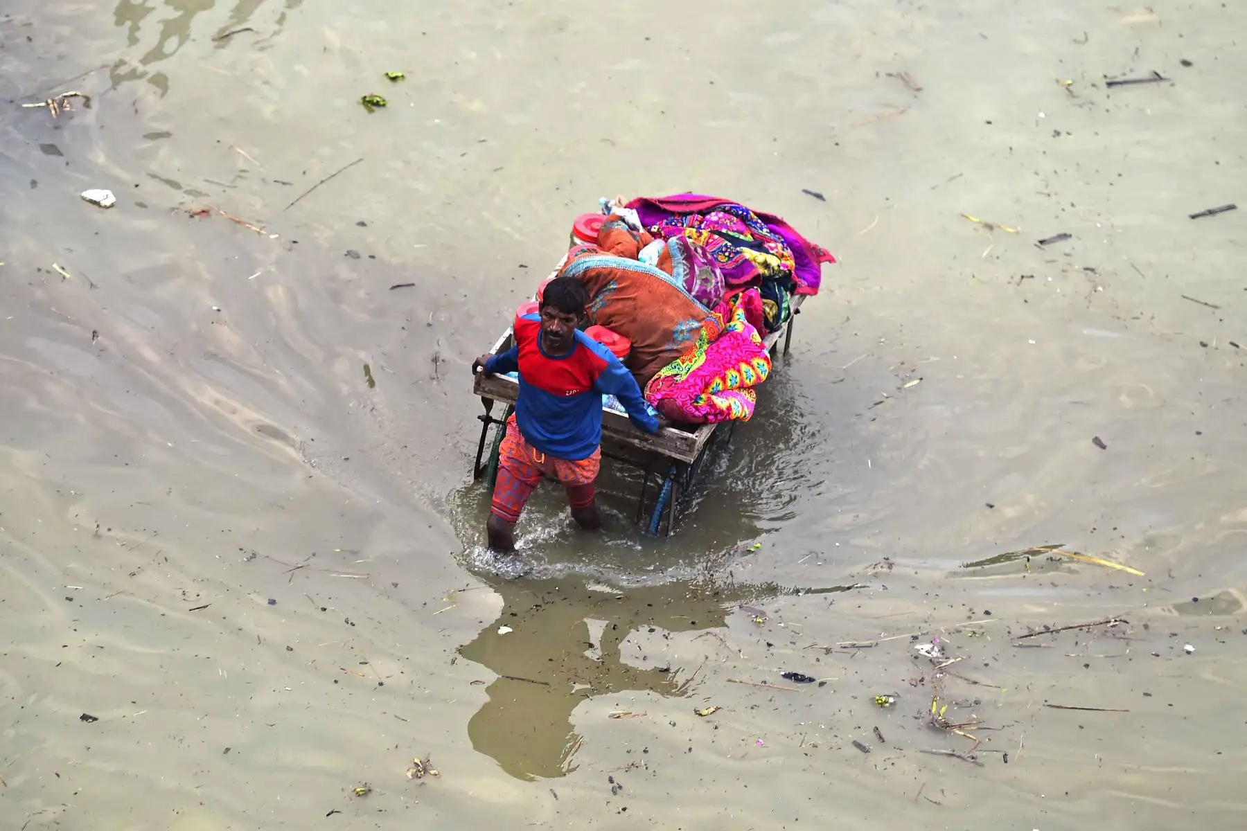 Los residentes afectados por las inundaciones de un área baja trasladan sus pertenencias en un carro de mano a un lugar más seguro a orillas del río Ganges luego de las fuertes lluvias monzónicas en Allahabad . Foto: AFP