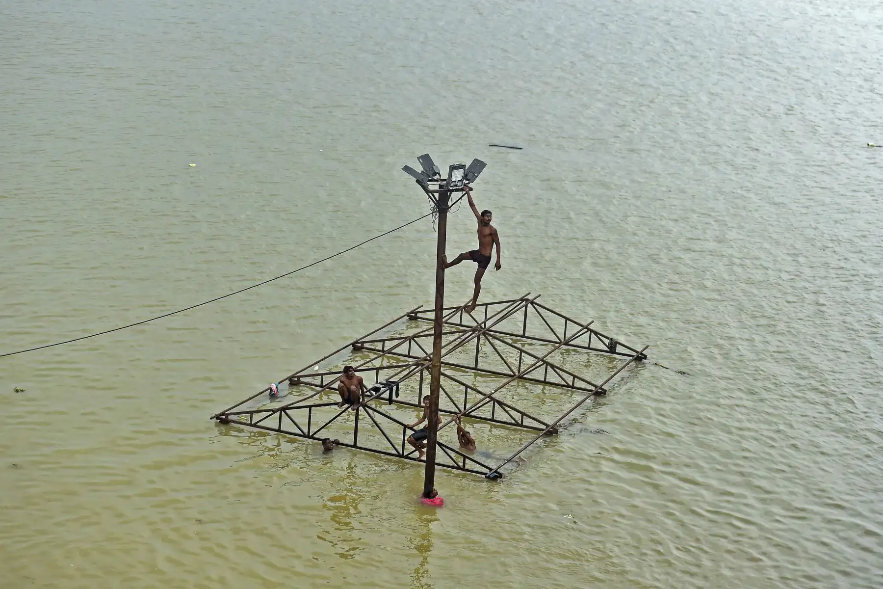 Un hombre se sumerge en el río Ganges desbordado después de las lluvias en Allahabad. Foto: AFP