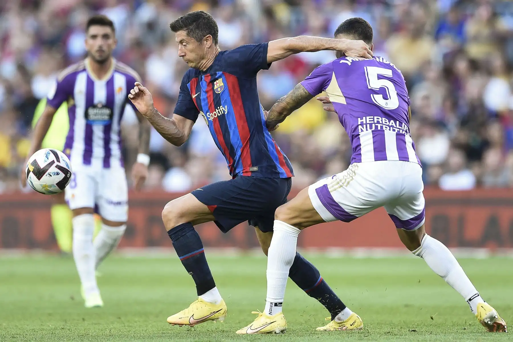 El delantero polaco de Barcelona, Robert Lewandowski (L), lucha por el balón con el defensor español del Real Valladolid, Javi Sánchez, durante el partido de fútbol de la Liga española entre el FC Barcelona y el Real Valladolid FC en el estadio Camp Nou de Barcelona. Foto: AFP