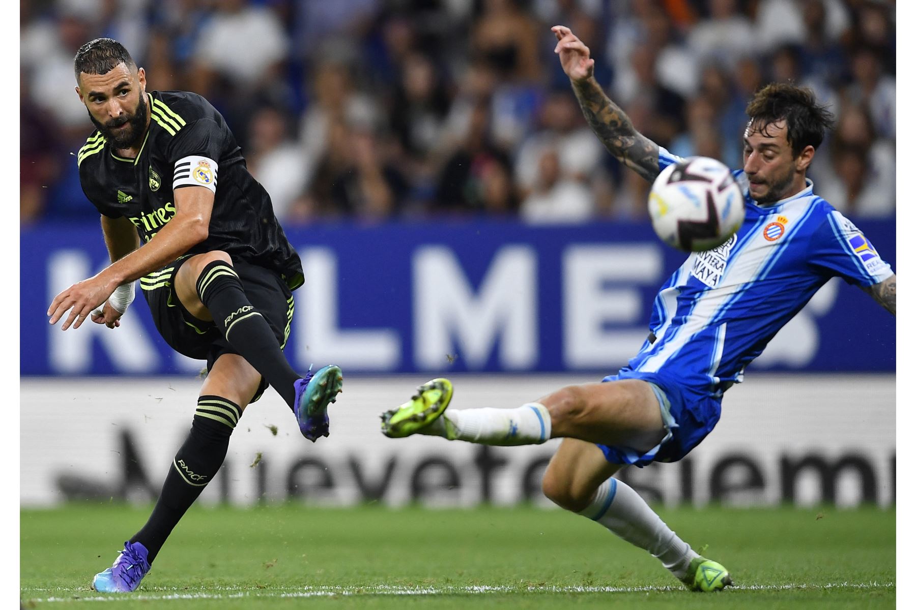 El delantero francés del Real Madrid, Karim Benzema, es abordado por el defensor español del Espanyol, Fernando Calero, durante el partido de fútbol de la Liga española. Foto: AFP