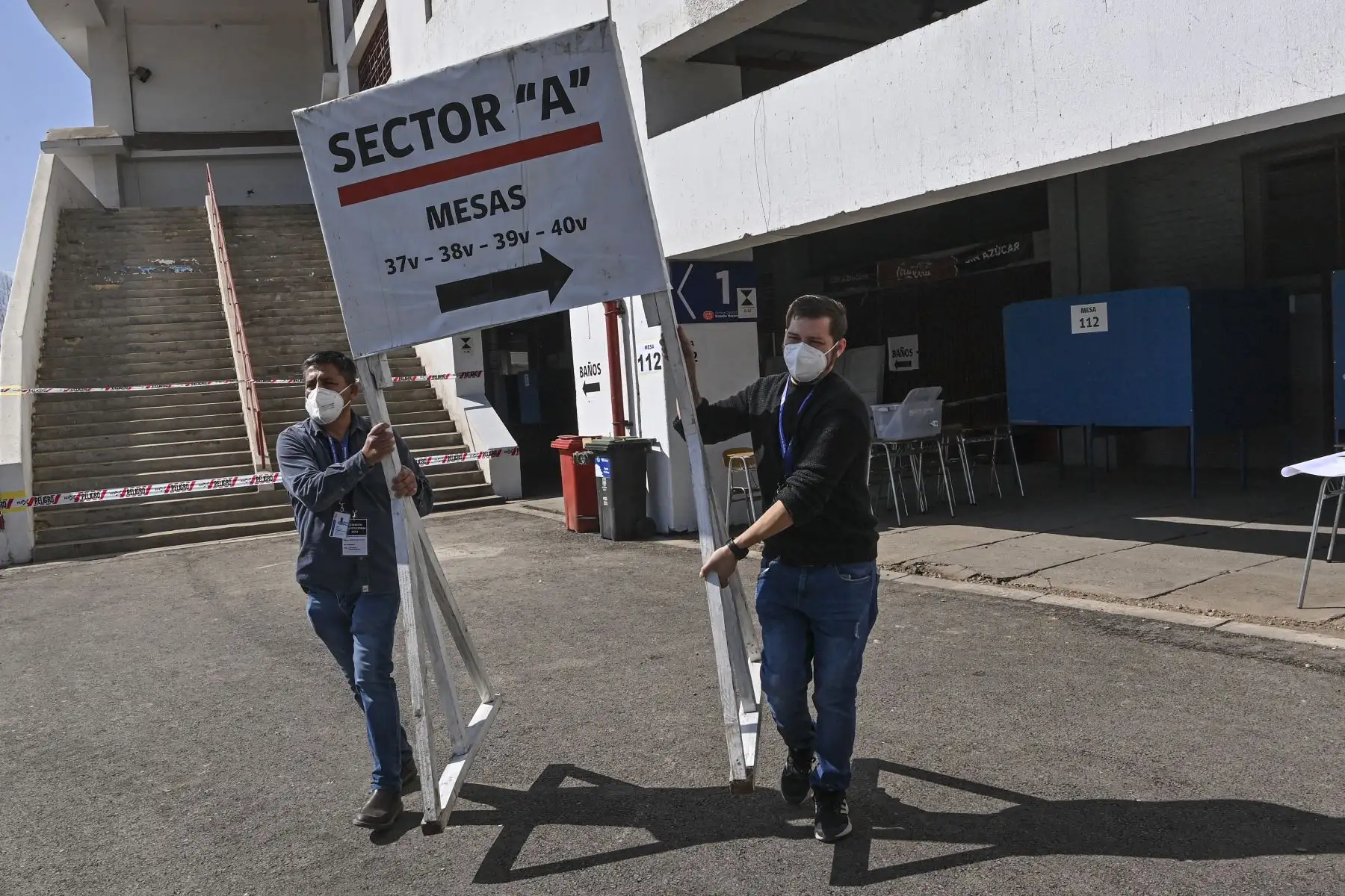 Los trabajadores del municipio de Nunoa preparan una mesa de votación previos a las votaciones. Cerca de 3.000 centros de votación abren este domingo en Chile para dar inicio a una de las votaciones más importantes de su historia reciente, en la que más de 15,1 millones chilenos decidirán si aprueban o rechazan la propuesta de nueva Constitución. Foto: AFP