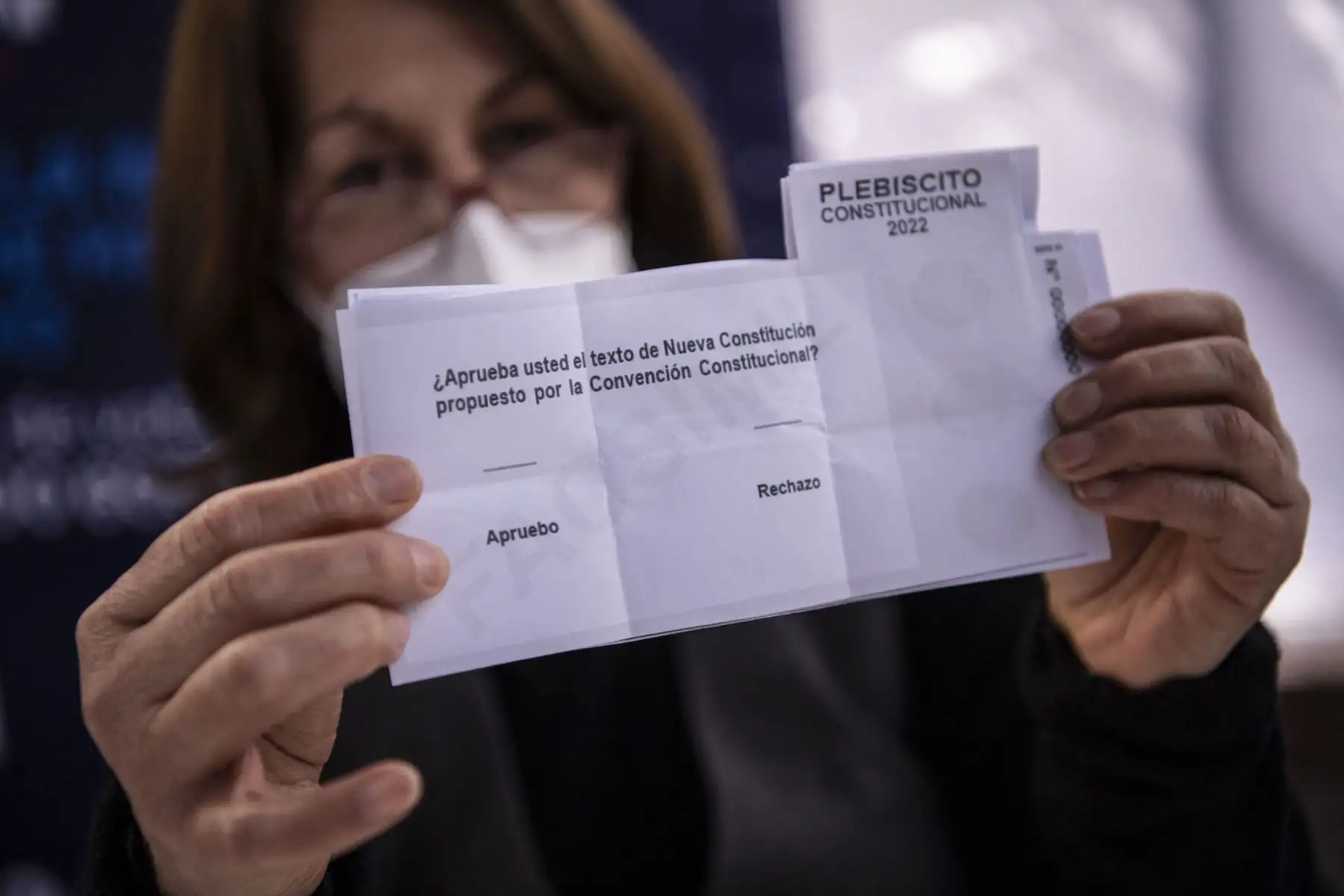 Un trabajador de la municipalidad de Providencia muestra una papeleta en un colegio electoral antes del referéndum. Cerca de 3.000 centros de votación abren este domingo en Chile para dar inicio a una de las votaciones más importantes de su historia reciente, en la que más de 15,1 millones chilenos decidirán si aprueban o rechazan la propuesta de nueva Constitución. Foto: AFP