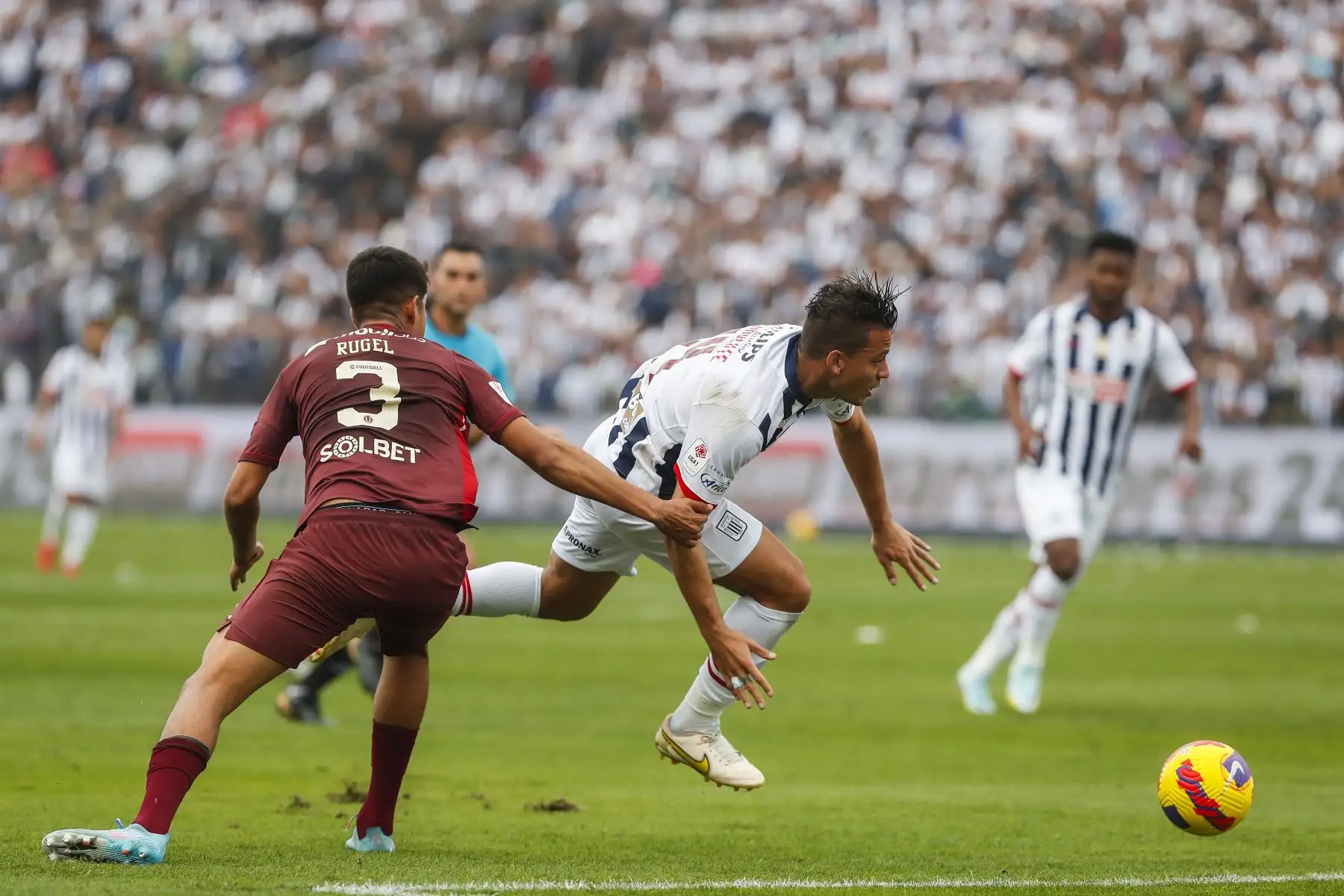 Cristian Benavente de Alianza Lima disputa un balón con Rugel de Universitario durante partido por la fecha diez de la Liga 1, en Matute. Foto: ANDINA/Renato Pajuelo