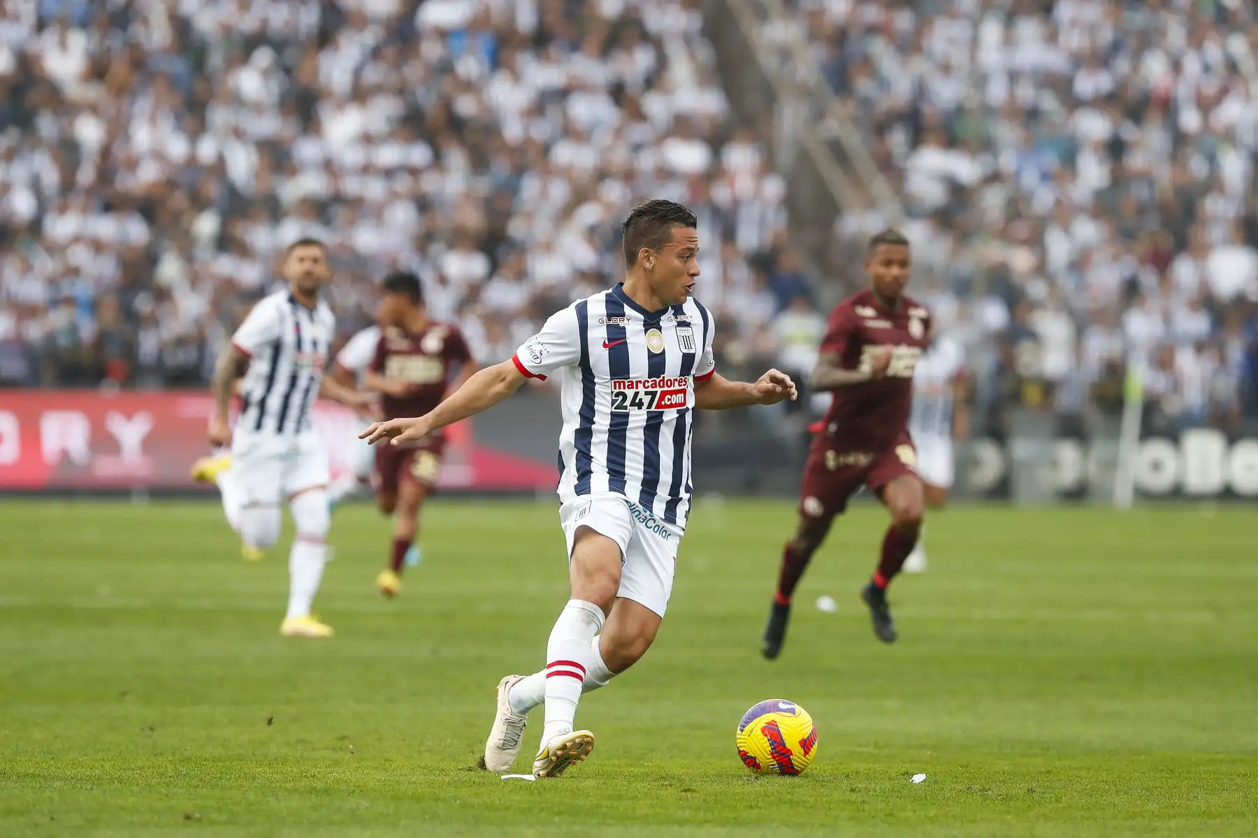 Cristian Benavente de Alianza Lima conduce el balón ante la marca de Universitario durante partido por la fecha diez del Torneo Clausura, en Matute. Foto: ANDINA/Renato Pajuelo