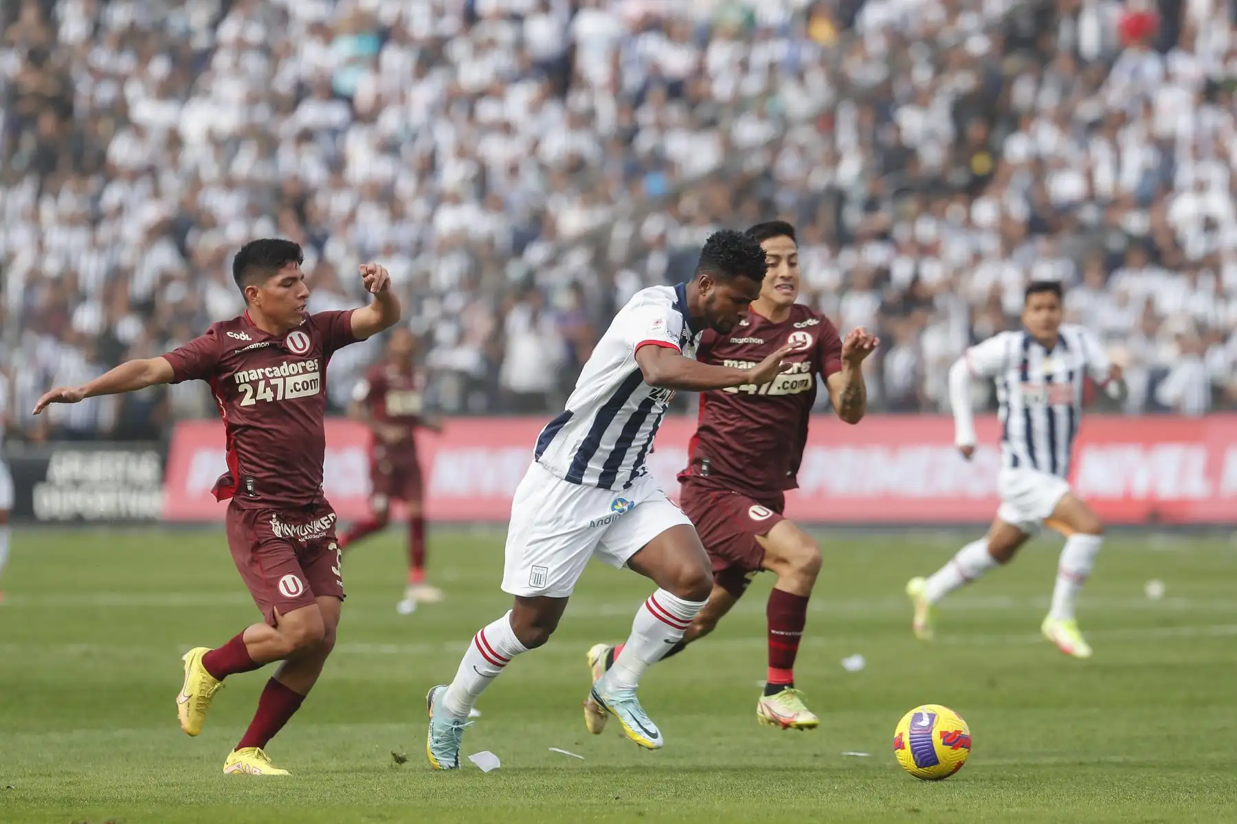 Aldair Rodríguez de Alianza Lima conduce el balón ante la marca de Universitario durante partido por la décima fecha de la Liga 1, en Matute. Foto: ANDINA/Renato Pajuelo
