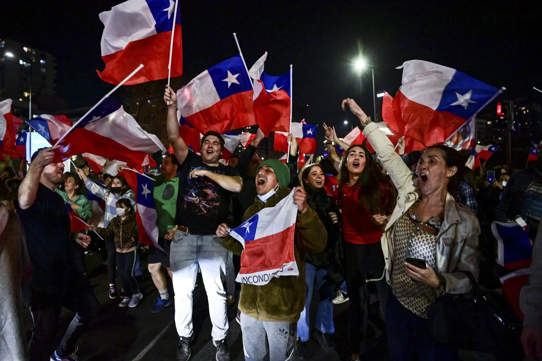 Personas que rechazan el nuevo proyecto de constitución celebran tras conocer los primeros resultados de la votación del referéndum, en Santiago, el 4 de septiembre de 2022.
Foto: AFP
