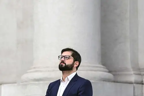 Sirenas policiales y olor a gases lacrimógenos antecedieron la ceremonia que se llevó a cabo en el palacio de gobierno. Foto: AFP