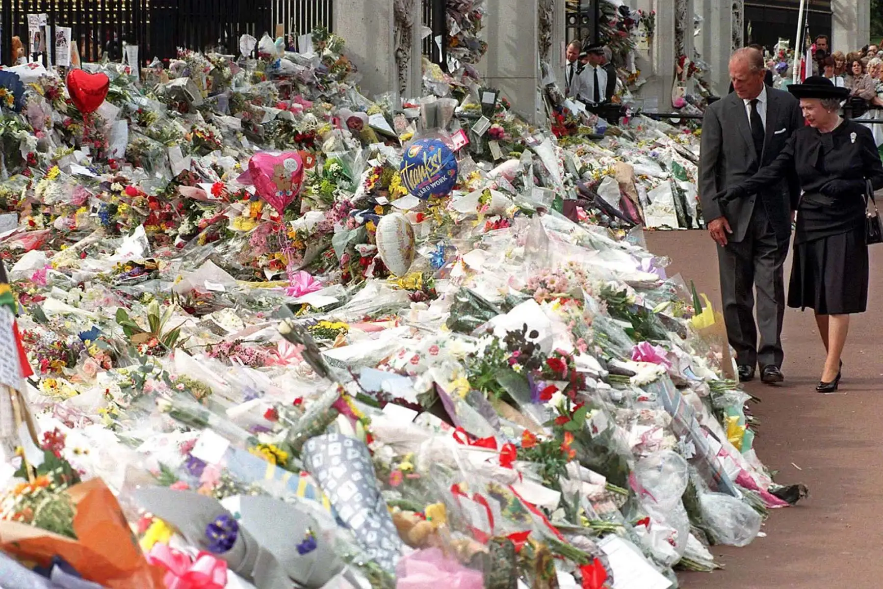El duque de Edimburgo y la reina Isabel ven las miles de flores y tributos dejados afuera del Palacio de Kensington en memoria de Diana, princesa de Gales, el 5 de septiembre de 1997. Foto: AFP