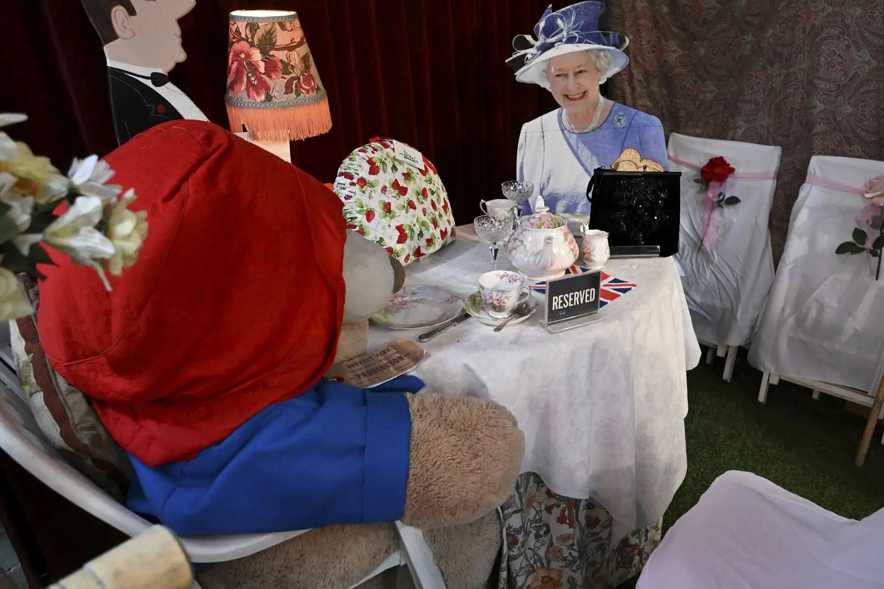 Un cartón de tamaño natural recortado de la reina Isabel II con el oso Paddington sentado en una mesa para el té se exhibe en el salón de té inglés Rose Tree Cottage en Pasadena, California, luego de la muerte de la reina el 8 de septiembre de 2022. Foto: AFP