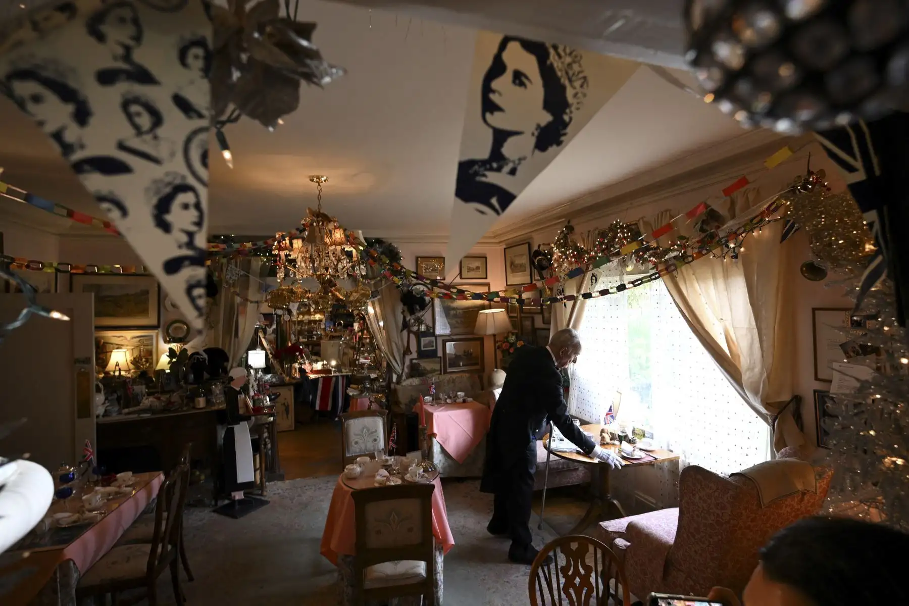 El propietario Edmund Fry ofrece bebidas de flores de saúco para los visitantes en su salón de té inglés Rose Tree Cottage en Pasadena, California, luego de la muerte hoy de la reina Isabel II el 8 de septiembre de 2022. Foto: AFP