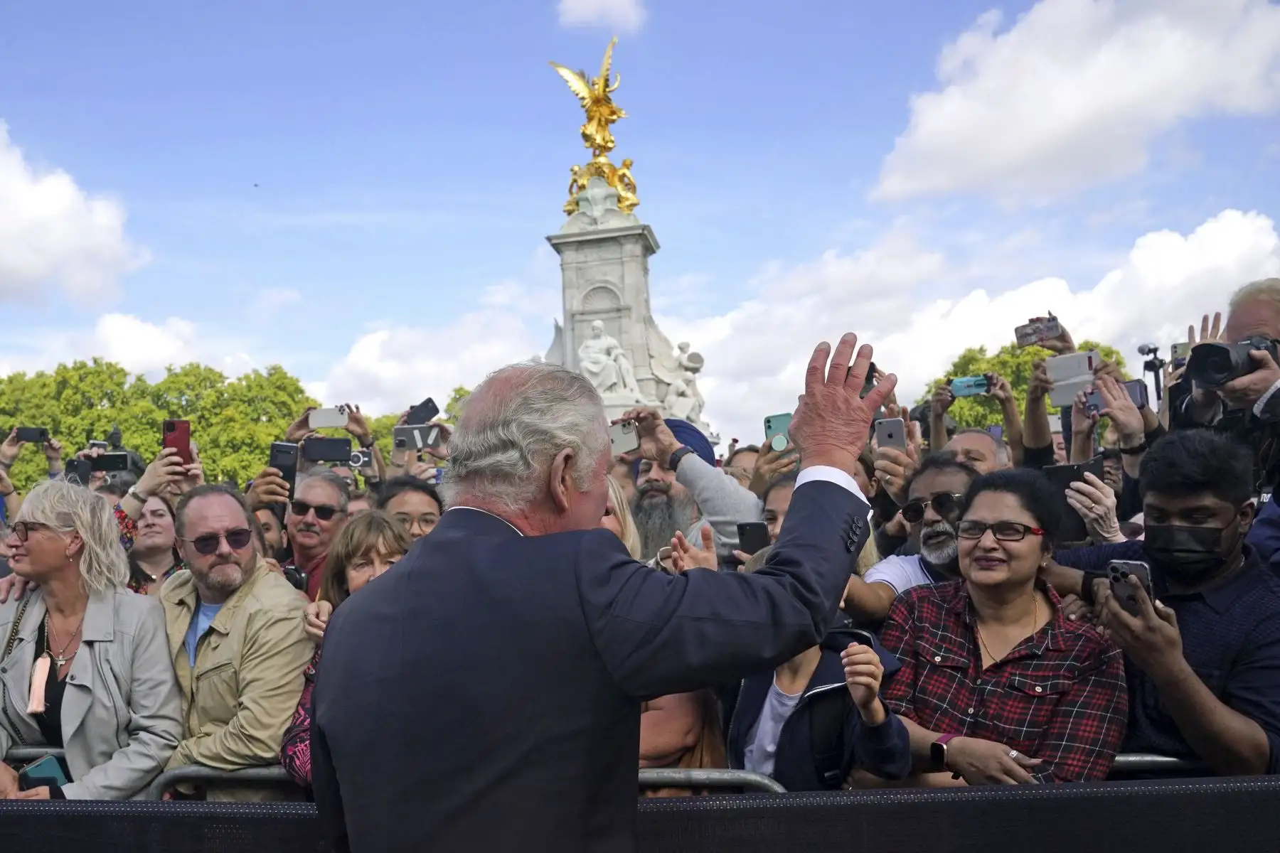 El rey Carlos III de Gran Bretaña saluda a los miembros del público que esperaban entre la multitud a su llegada al Palacio de Buckingham en Londres, el 9 de septiembre de 2022, un día después de que la reina Isabel II muriera a la edad de 96 años. Foto: AFP