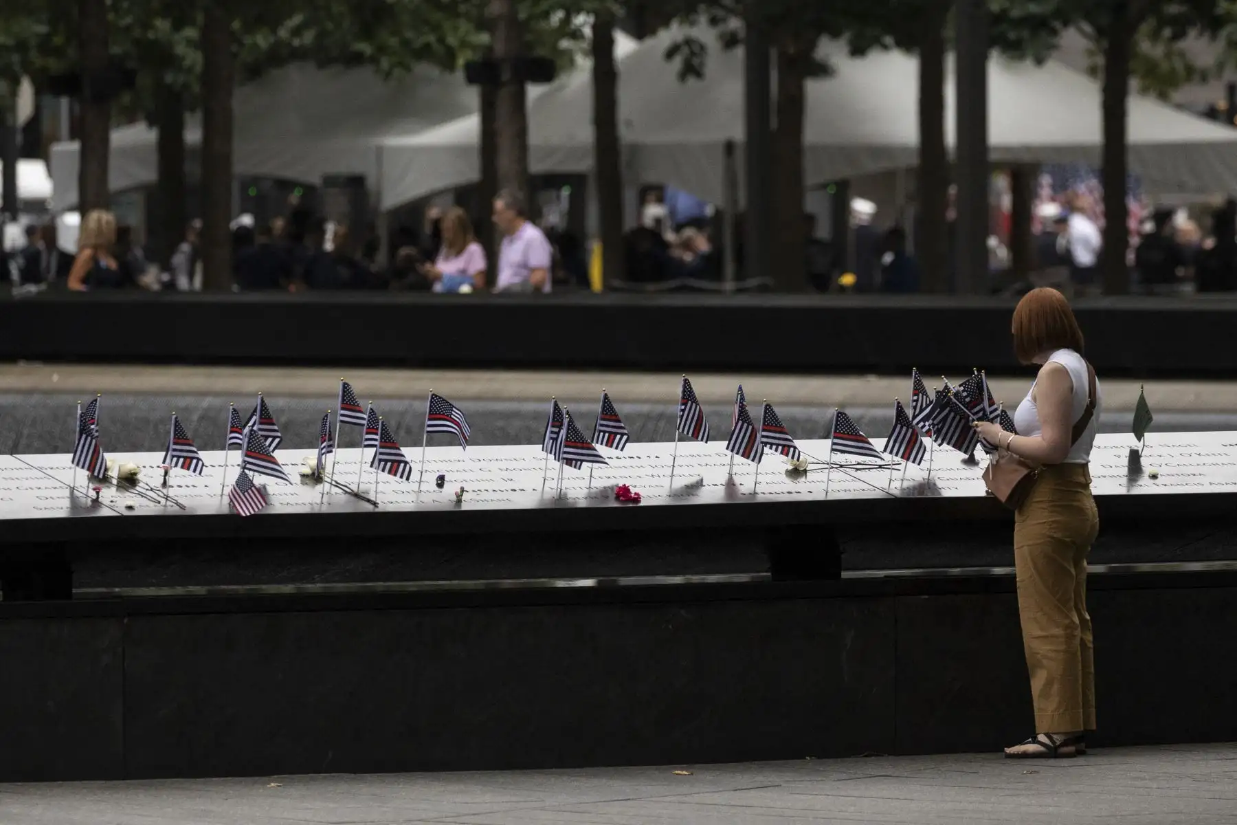 Familiares de las víctimas colocan banderas estadounidenses en el monumento conmemorativo del 11 de septiembre en la ciudad de Nueva York el 11 de septiembre de 2022, en el 21.º aniversario de los ataques contra el World Trade Center, el Pentágono y Shanksville, Pensilvania. Foto: AFP