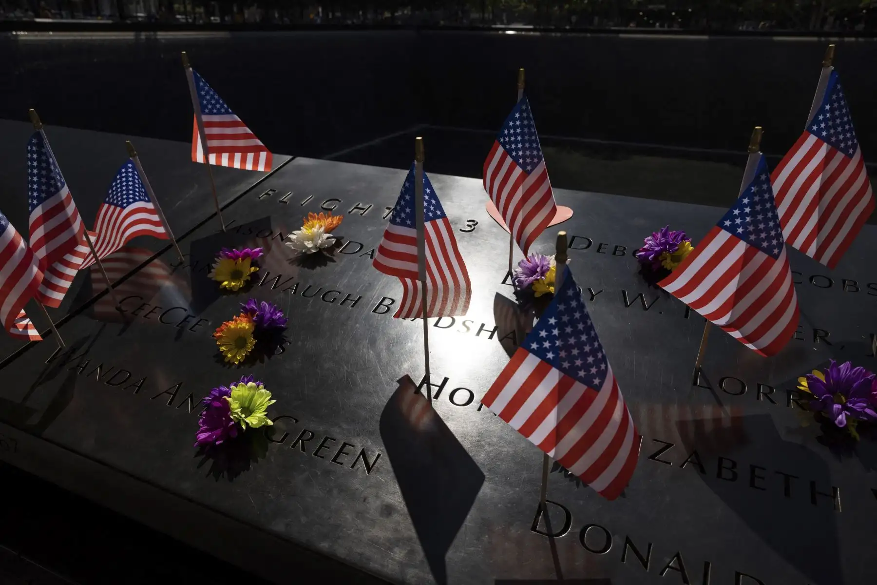 Flores y banderas estadounidenses en el monumento conmemorativo del 11 de septiembre en Nueva York en el 21 aniversario de los ataques al World Trade Center, el Pentágono y Shanksville, Pensilvania. Foto: AFP