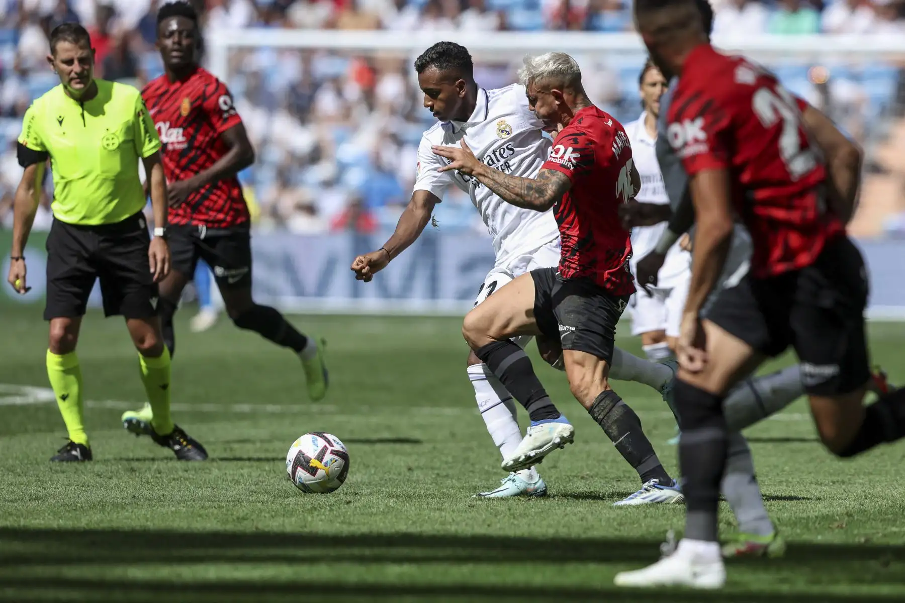 El delantero brasileño del Real Madrid, Rodrygo (C), lucha por el balón con el defensor español del Real Mallorca, Pablo Maffeo, durante el partido de fútbol de la liga española entre el Real Madrid CF y el RCD Mallorca en el estadio Santiago Bernabeu. Foto: AFP