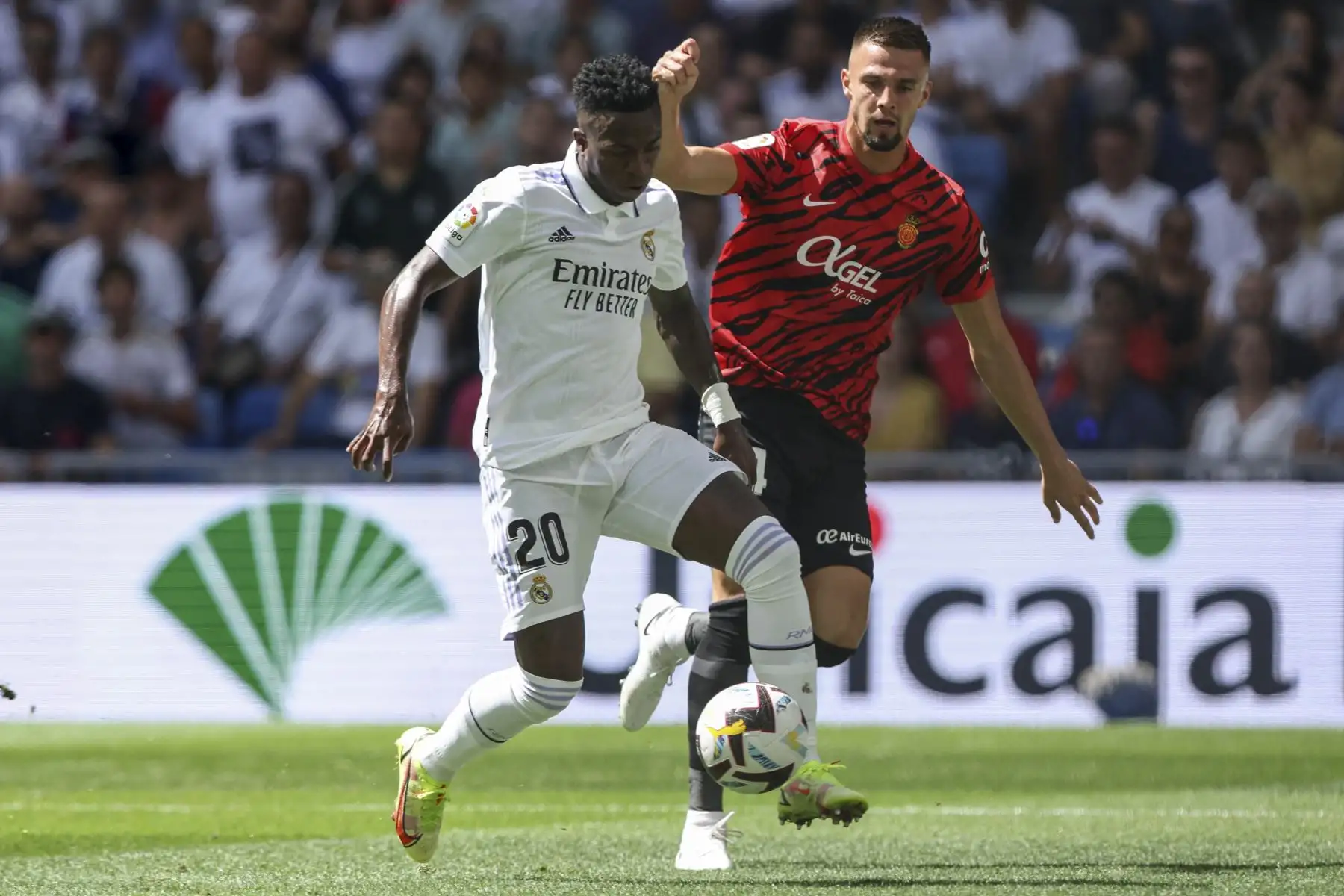 El delantero brasileño del Real Madrid, Vinicius Junior (L), lucha por el balón con el defensor eslovaco del Real Mallorca, Martin Valjent, durante el partido de fútbol de la liga española entre el Real Madrid CF y el RCD Mallorca en el estadio Santiago Bernabeu de Madrid. Foto: AFP