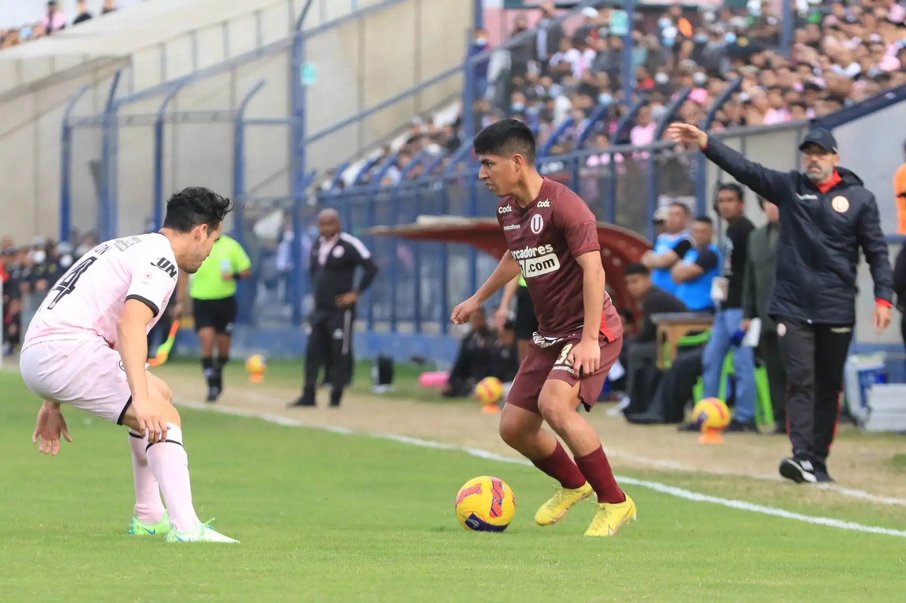 Piero Quispe de Universitario controla el balón ante la marca de su rival de Sport Boys durante partido por la jornada 11 del Torneo Clausura de la Liga 1, en el Estadio Iván Elías Moreno. Foto: Liga 1