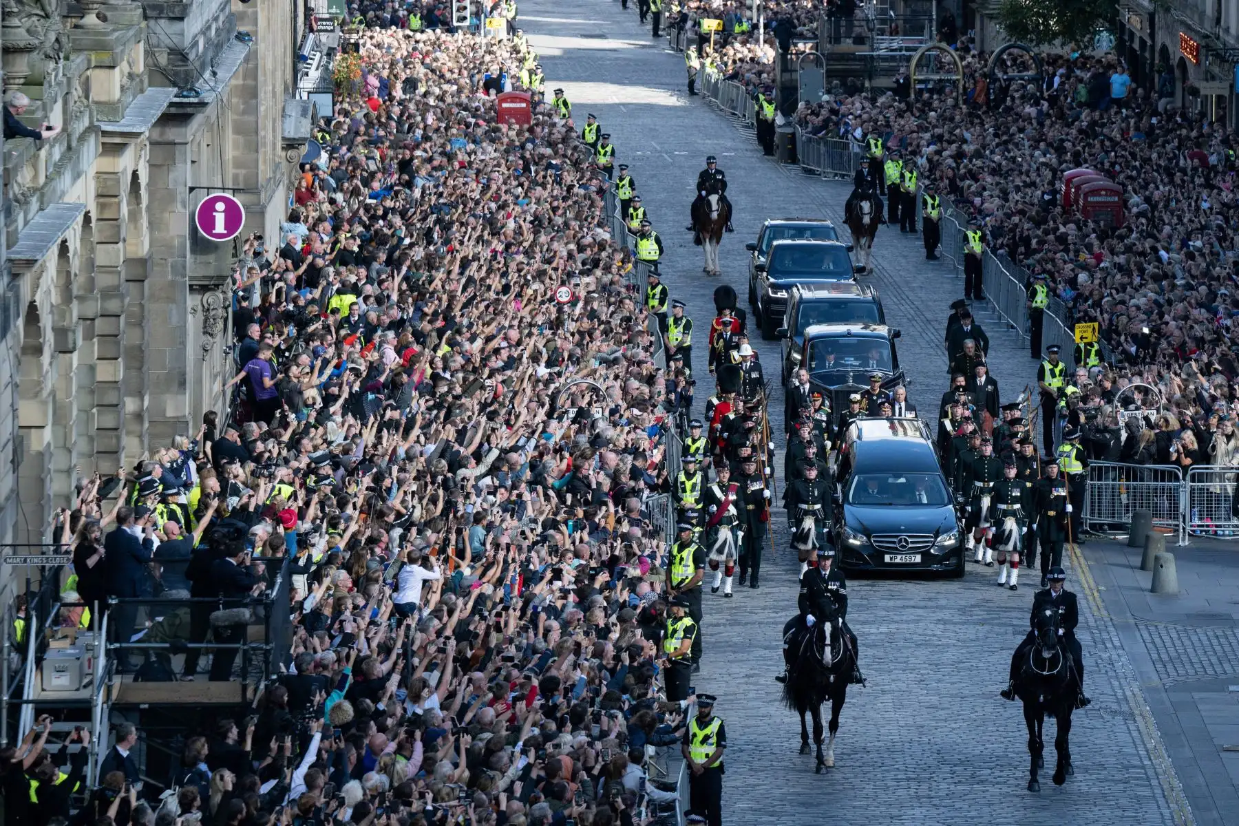 Los miembros del público observan la procesión del ataúd de la difunta reina Isabel II, desde el Palacio de Holyroodhouse hasta la Catedral de St Giles en Edimburgo, en la Royal Mile.
Foto: AFP