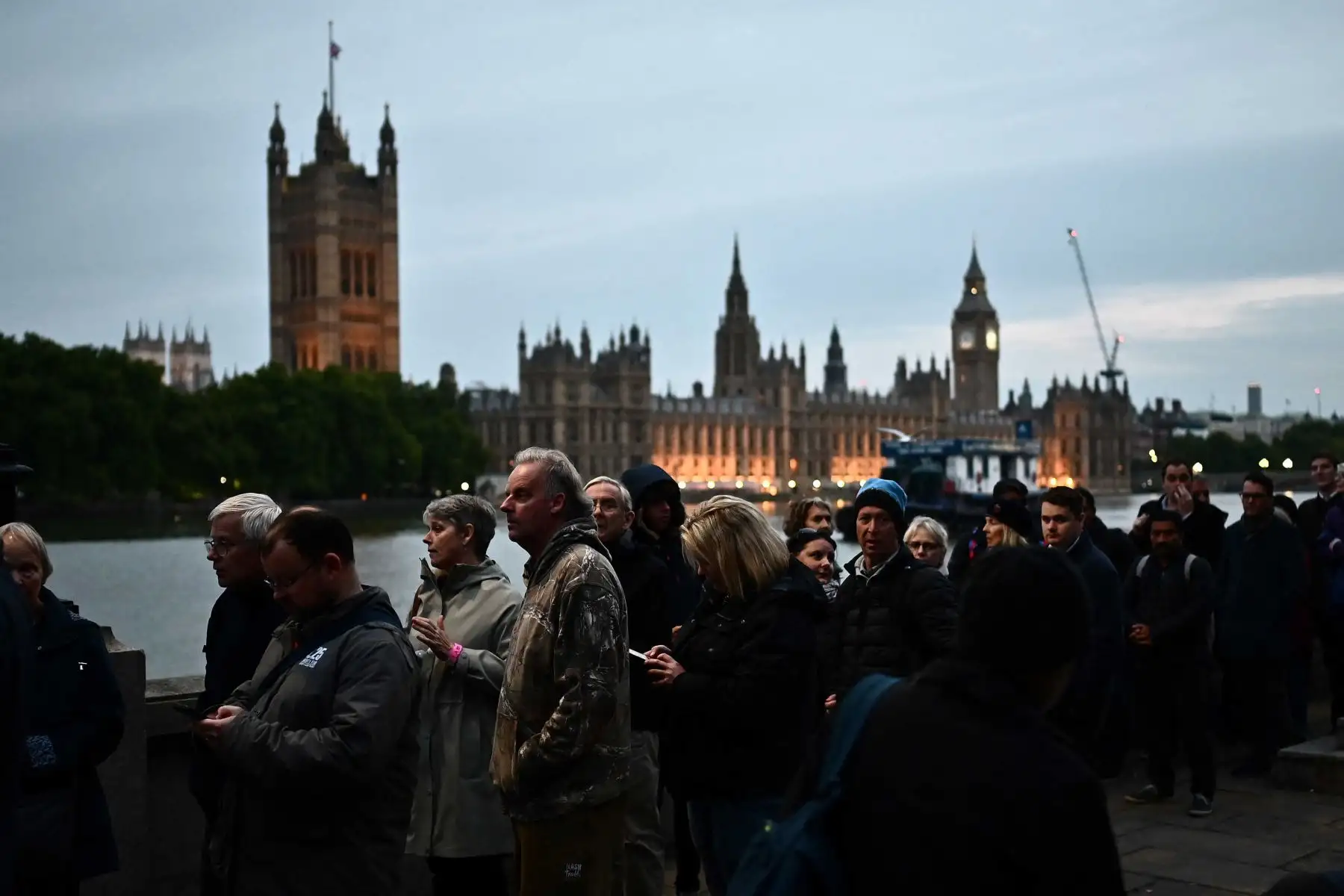 Los miembros del público hacen cola a lo largo de la orilla sur del río Támesis, frente al Palacio de Westminster, mientras esperan en la fila para presentar sus respetos a la difunta Reina Isabel II, en Londres. Foto: AFP