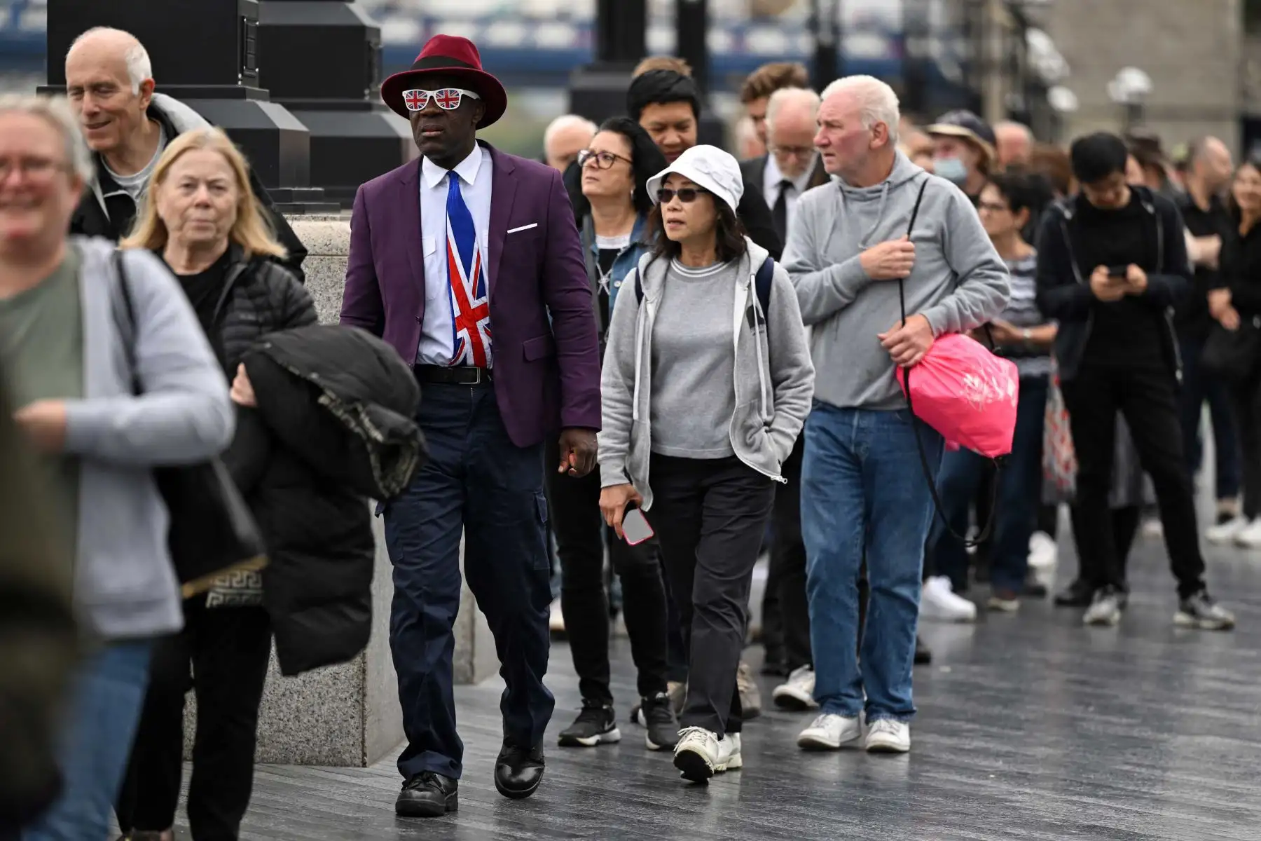 Público hace cola en la orilla sur del río Támesis, junto al Tower Bridge, mientras esperan en fila para presentar sus respetos a la difunta reina Isabel II, en Londres. Foto: AFP