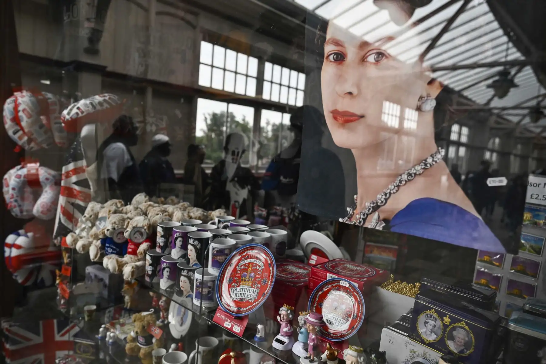 Un retrato de la reina Isabel II de Gran Bretaña se muestra en un escaparate donde se venden otros recuerdos de la familia real en Windsor. Foto: AFP