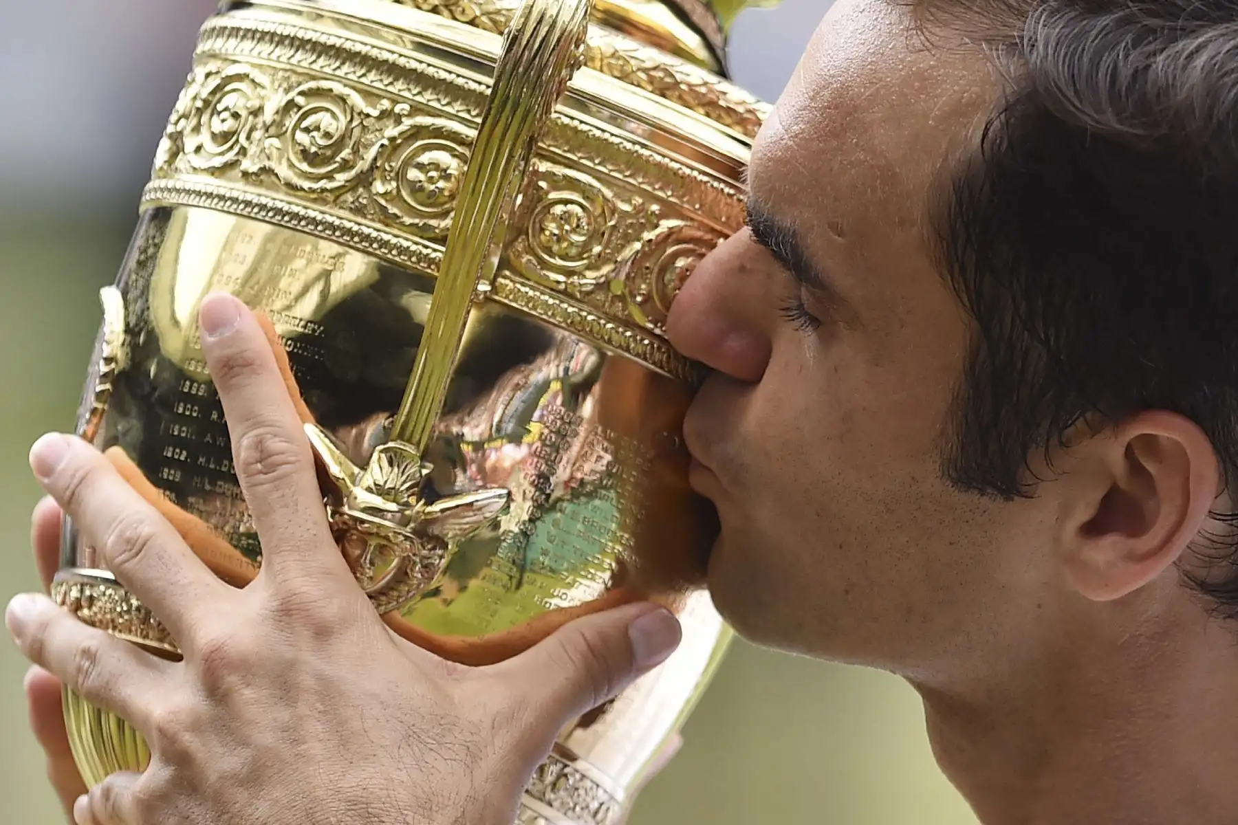 En esta foto de archivo tomada el 16 de julio de 2017, Roger Federer de Suiza besa el trofeo del ganador después de vencer a Marin Cilic de Croacia en su partido final individual masculino, durante la presentación del último día del Campeonato de Wimbledon 2017 . Foto: AFP