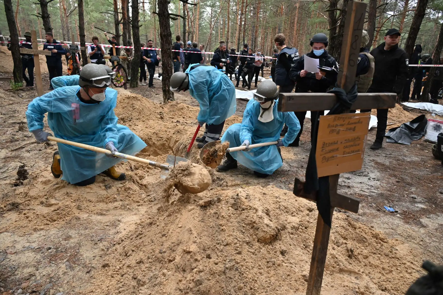 Técnicos forenses cavan una tumba en un bosque en las afueras de Izyum, este de Ucrania, el 16 de septiembre de 2022. - Ucrania dijo el 16 de septiembre de 2022 que había contado 450 tumbas en un solo lugar de entierro cerca de Izyum después de recuperar la ciudad del este de los rusos. Foto: AFP