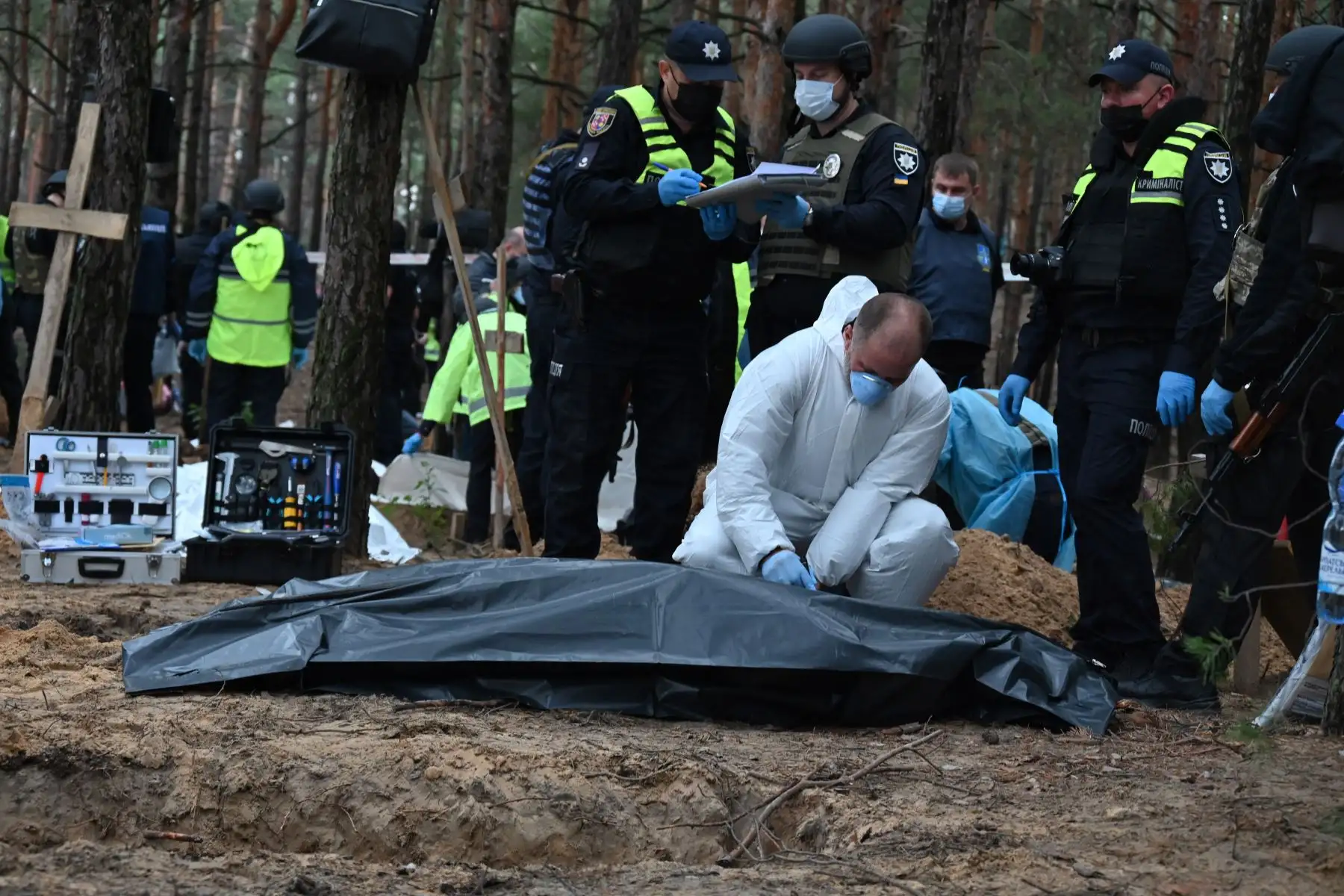Técnicos forenses cavan una tumba en un bosque en las afueras de Izyum, este de Ucrania, el 16 de septiembre de 2022. - Ucrania dijo el 16 de septiembre de 2022 que había contado 450 tumbas en un solo lugar de entierro cerca de Izyum después de recuperar la ciudad del este de los rusos. Foto: AFP