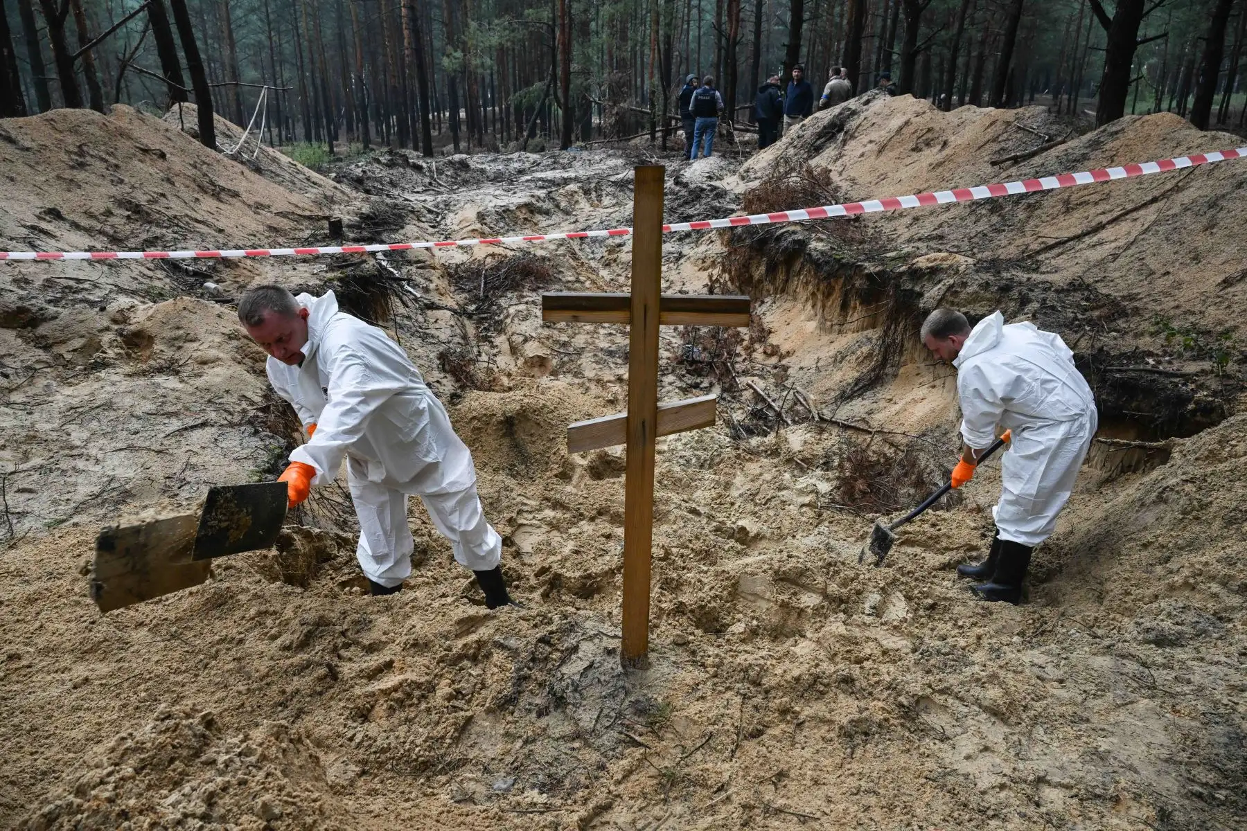 Técnicos forenses cavan una tumba en un bosque en las afueras de Izyum, este de Ucrania, el 16 de septiembre de 2022. - Ucrania dijo el 16 de septiembre de 2022 que había contado 450 tumbas en un solo lugar de entierro cerca de Izyum después de recuperar la ciudad del este de los rusos. Foto: AFP