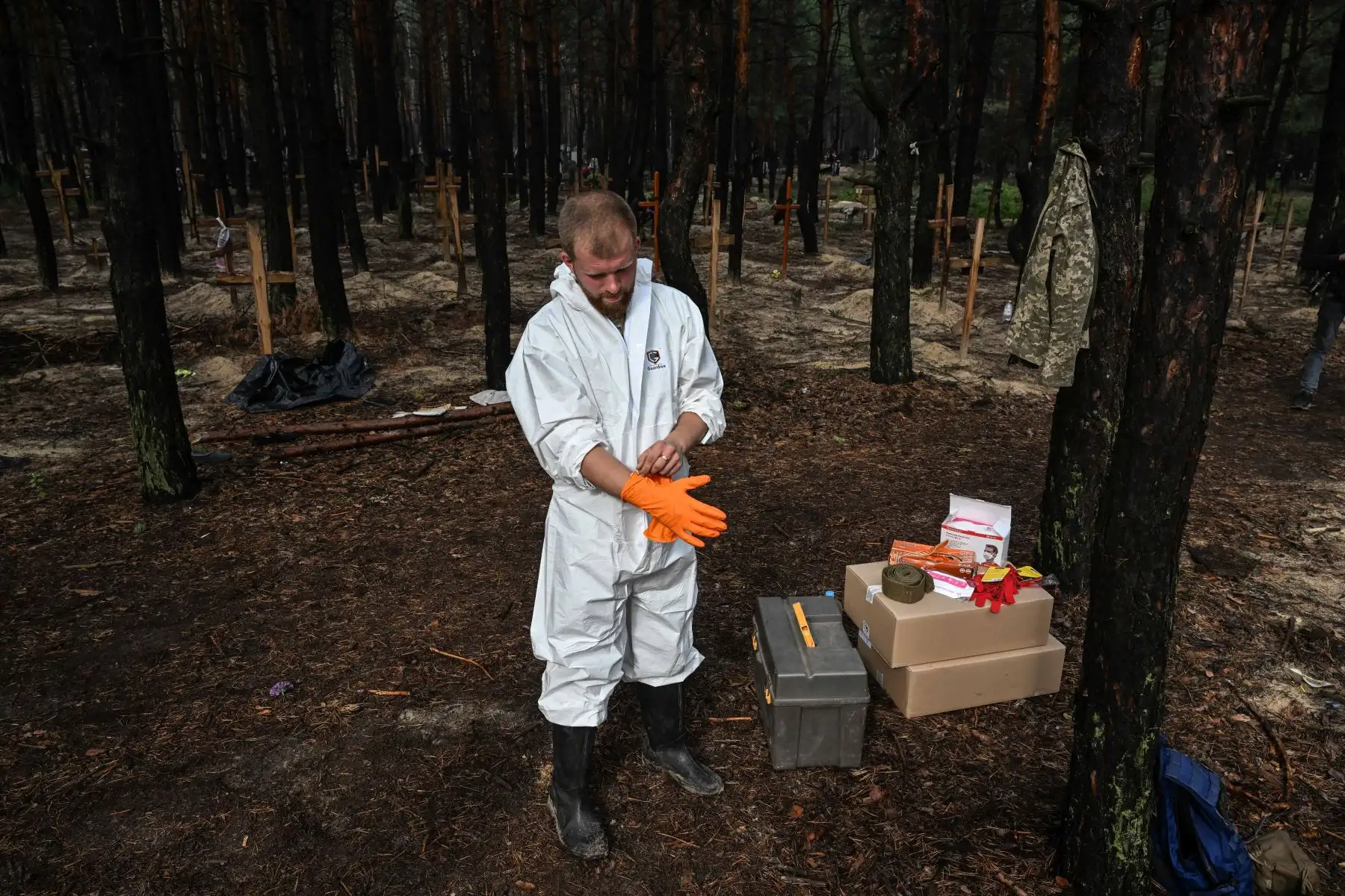 Técnicos forenses cavan una tumba en un bosque en las afueras de Izyum, este de Ucrania, el 16 de septiembre de 2022. - Ucrania dijo el 16 de septiembre de 2022 que había contado 450 tumbas en un solo lugar de entierro cerca de Izyum después de recuperar la ciudad del este de los rusos. Foto: AFP