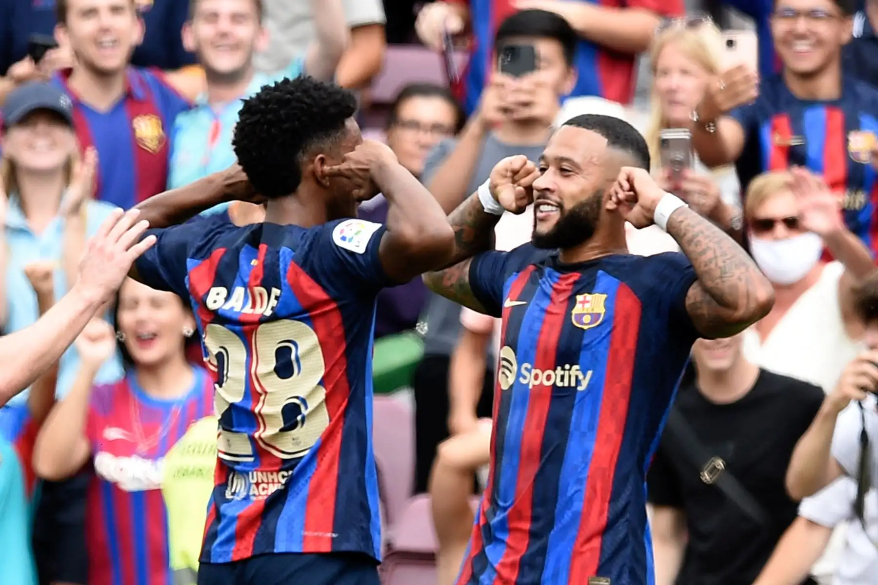 El delantero holandés de Barcelona Memphis Depay (R) celebra marcar el segundo gol de su equipo durante el partido de fútbol de la Liga española entre el FC Barcelona y Elche CF en el estadio Camp Nou de Barcelona. Foto: AFP