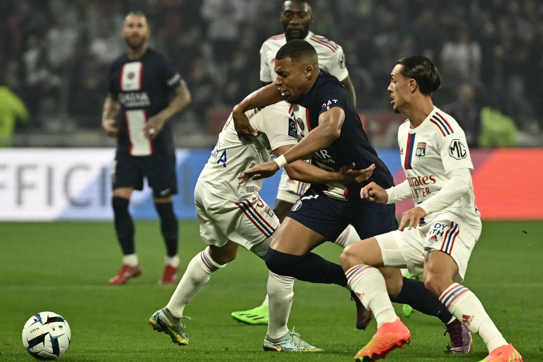 El delantero francés del Paris Saint-Germain, Kylian Mbappe (C), intenta controlar el balón durante el partido de fútbol de la L1 francesa entre el Olympique Lyonnais (OL) y el Paris Saint-Germain (PSG) en el estadio Groupama en Decines-Charpieu, en el centro-este de Francia. Foto: AFP