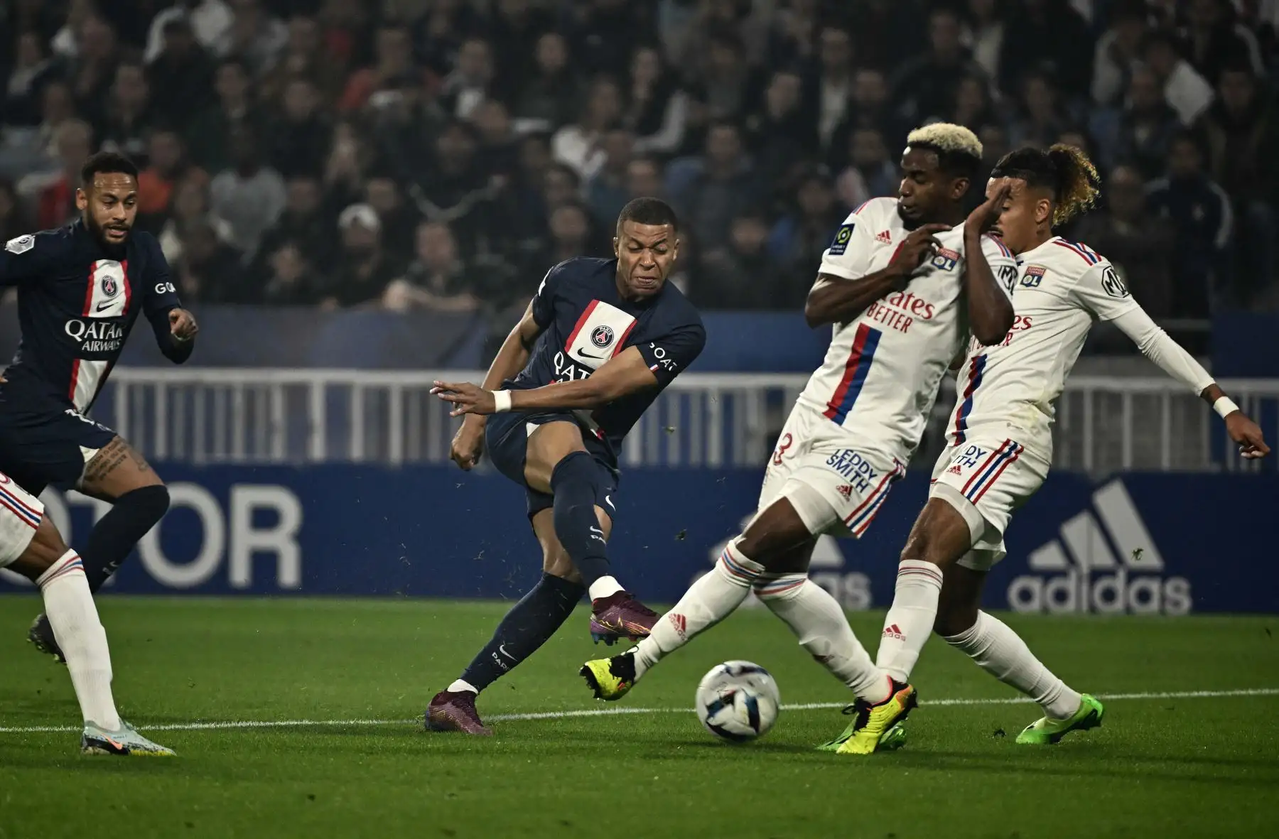 El delantero francés del Paris Saint-Germain, Kylian Mbappe (centro), patea el balón durante el partido de fútbol francés L1 entre el Olympique Lyonnais (OL) y el Paris Saint-Germain (PSG) en el estadio Groupama en Decines-Charpieu, centro-este de Francia. Foto: AFP