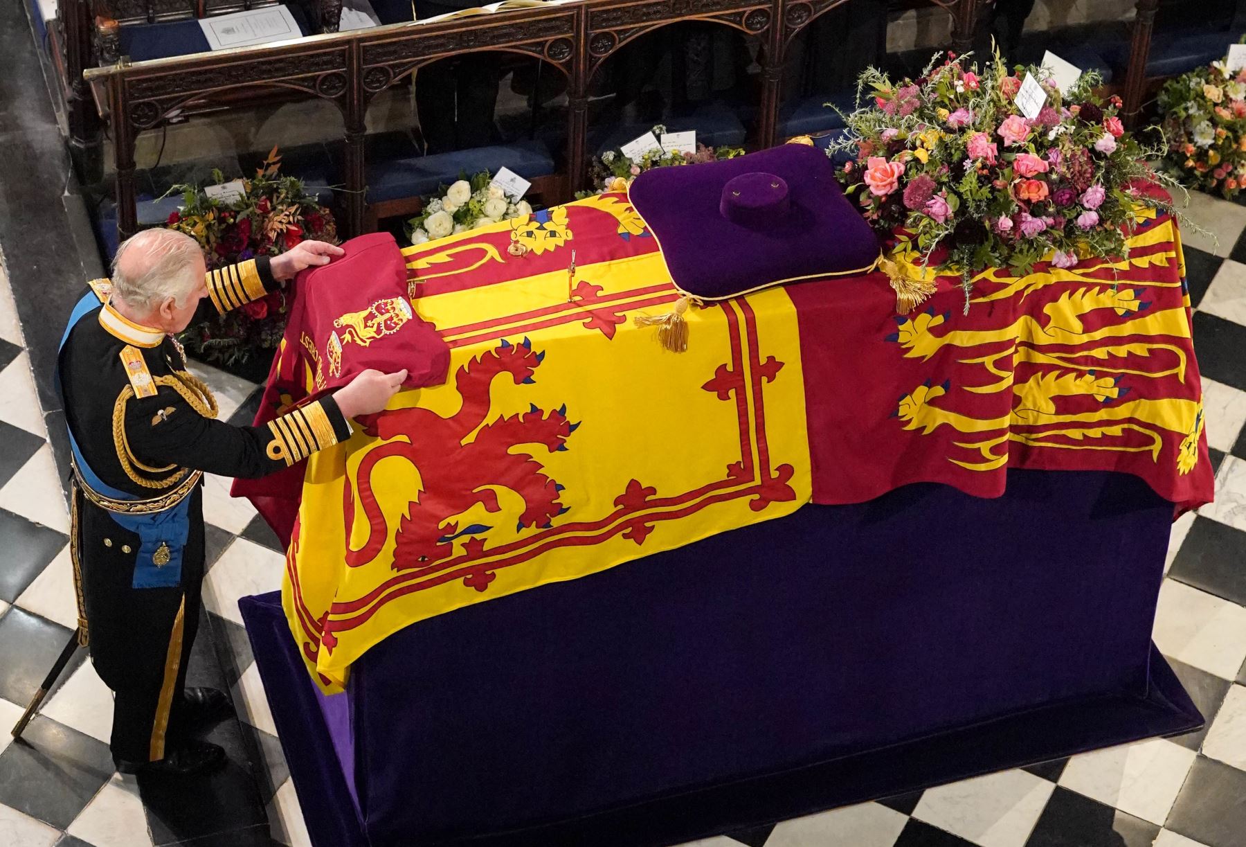 El rey Charles III coloca el escudo de quien en vida fue su madre, la reina Isabel II. Foto: AFP