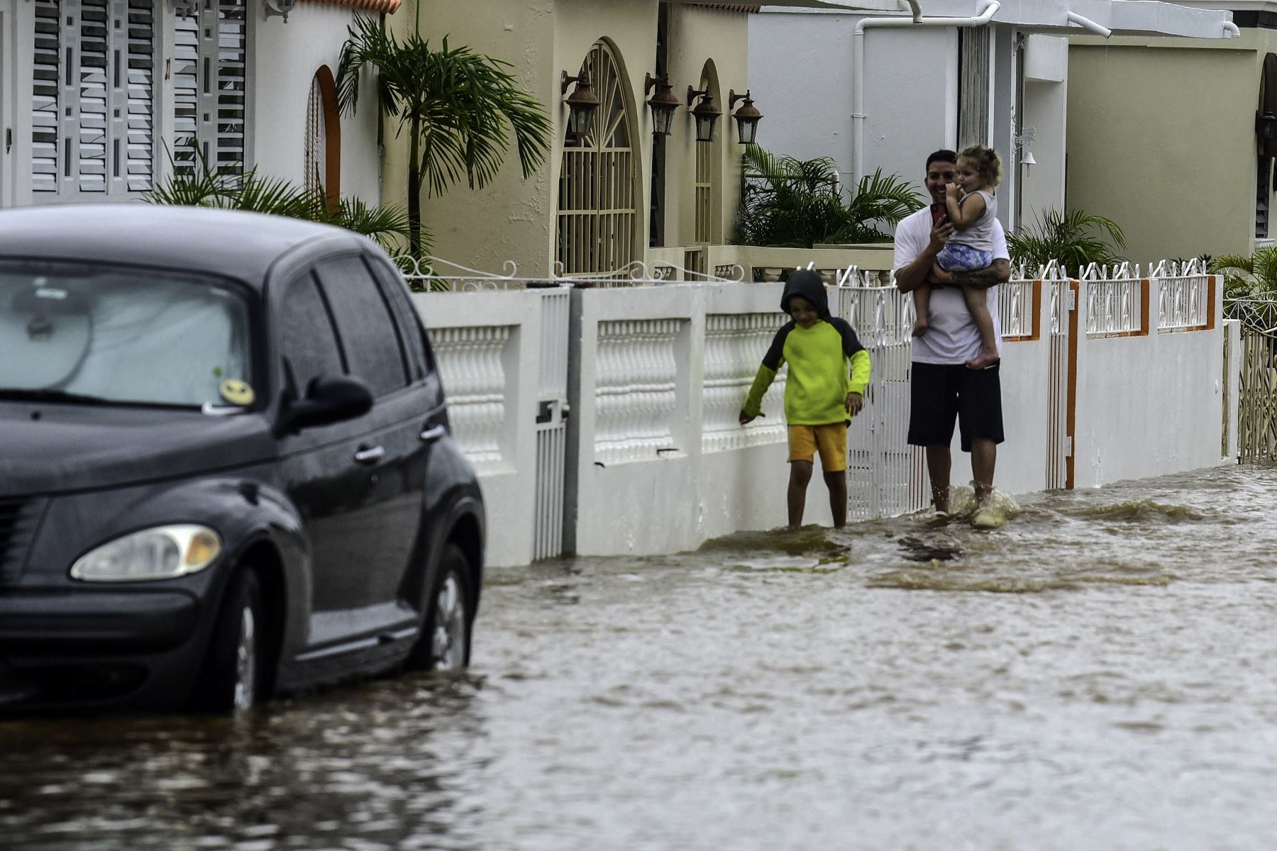 Un hombre y dos niños caminan en una calle inundada después del paso del huracán Fiona en Salinas, Puerto Rico.
Foto: AFP