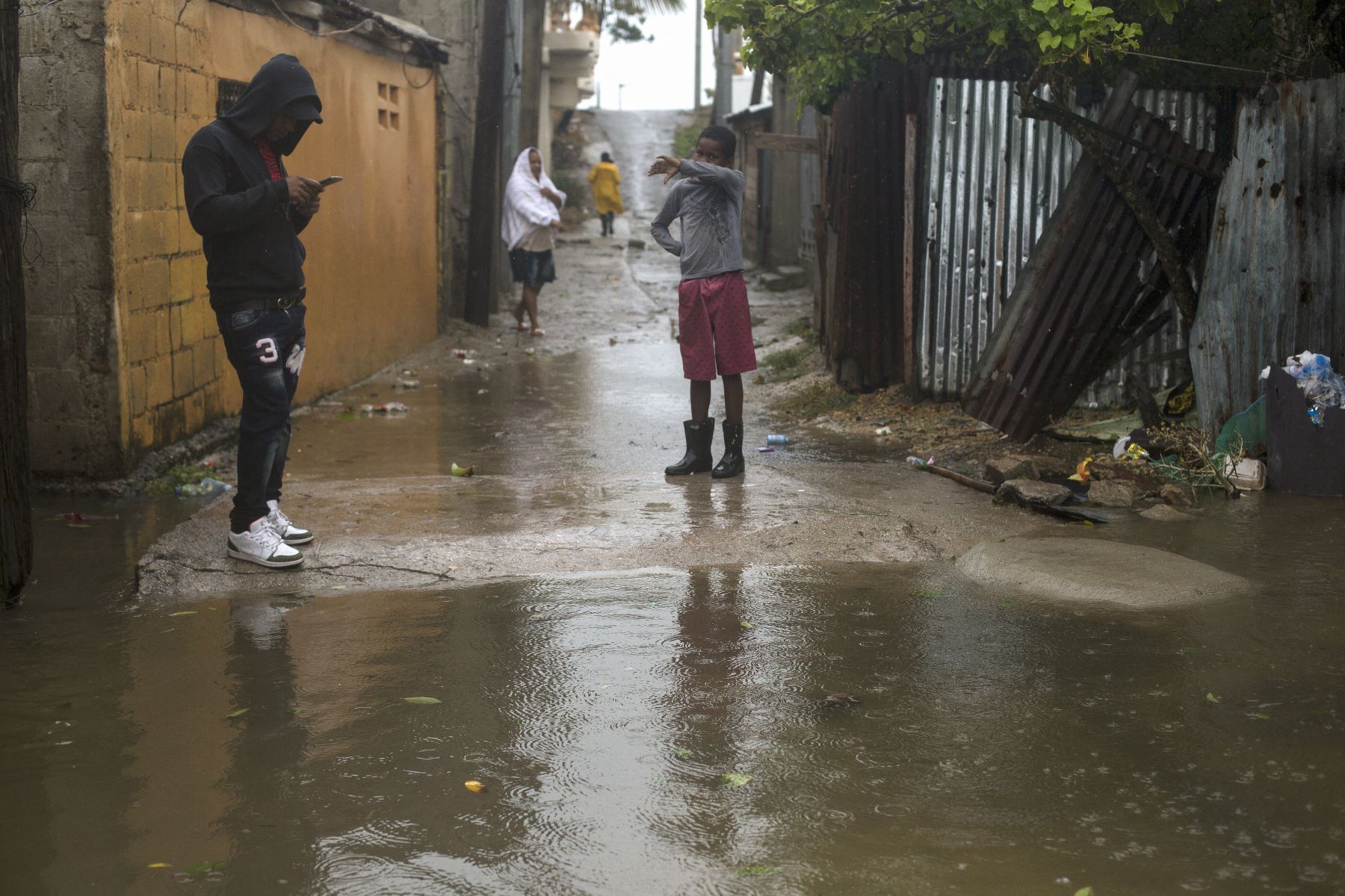 Personas permanecen junto a una calle inundada en Nagua, República Dominicana, tras el paso del huracán Fiona.
Foto: AFP