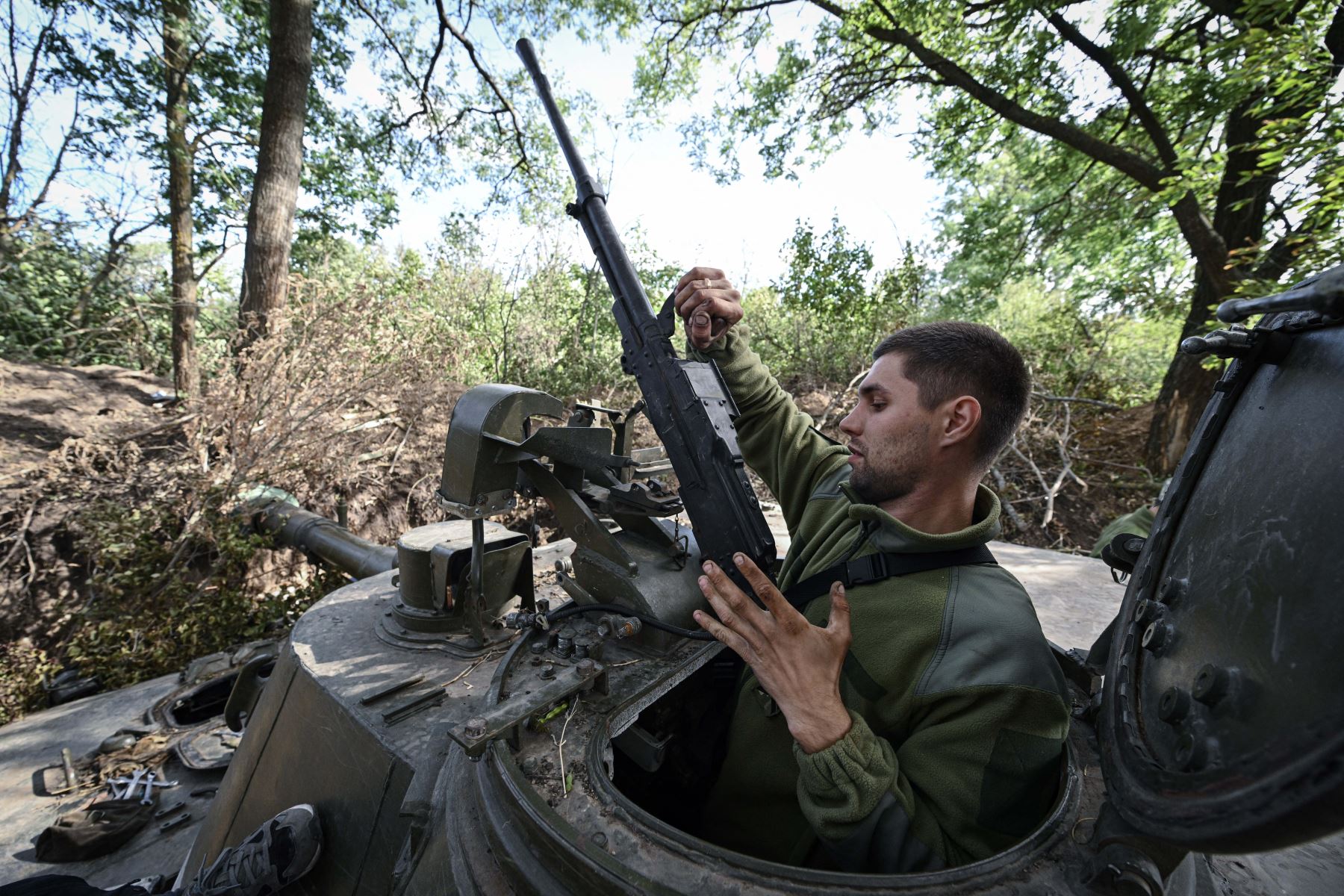 Un artillero ucraniano trabaja en un obús autopropulsado 2S3 Akatsiya en Ucrania. Foto: AFP.