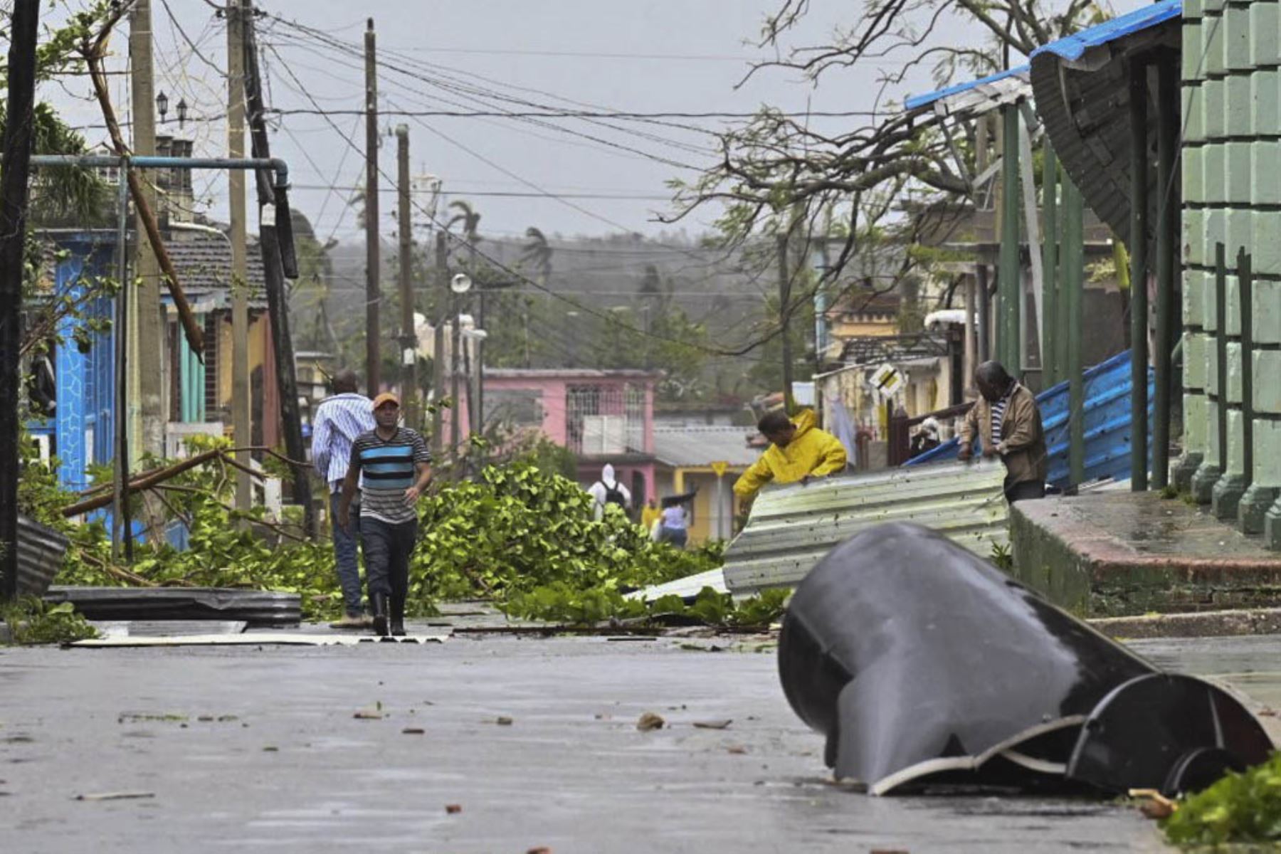 La gente limpia una calle en Consolación del Sur, Cuba, durante el paso del huracán Ian.  Foto : AFP