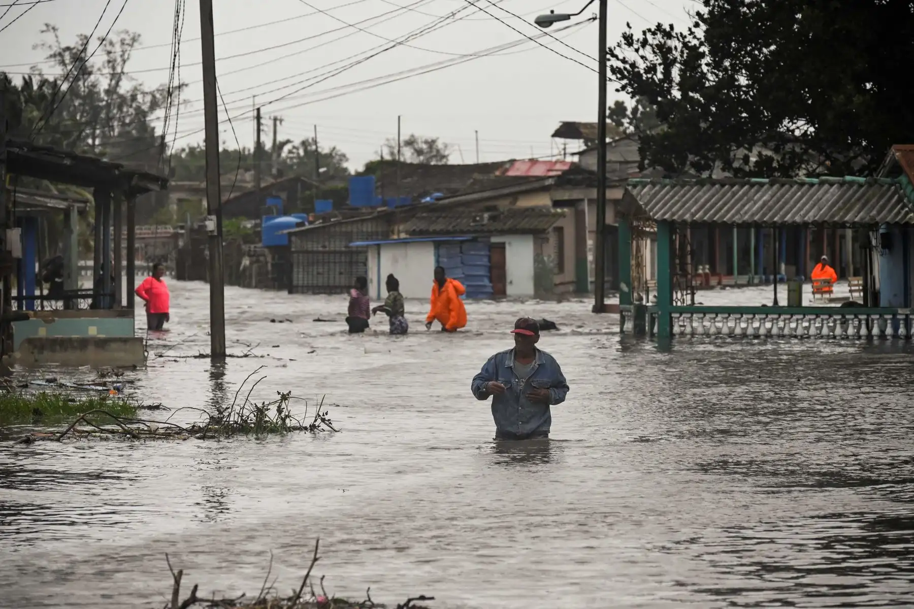 La gente camina por una calle inundada en Batabano, Cuba,  durante el paso del huracán Ian. Foto: AFP
