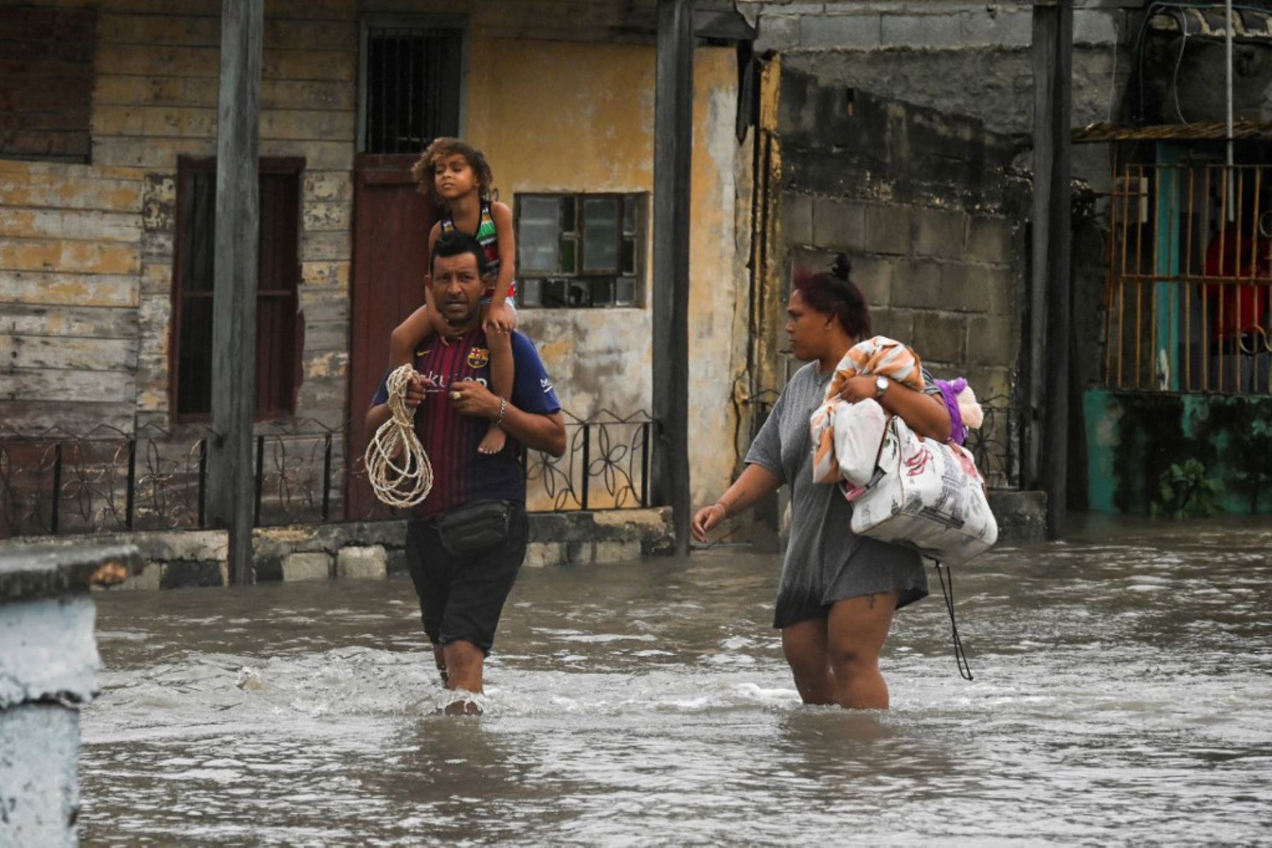 La gente camina por una calle inundada en Batabano, Cuba,  durante el paso del huracán Ian. Foto: AFP
