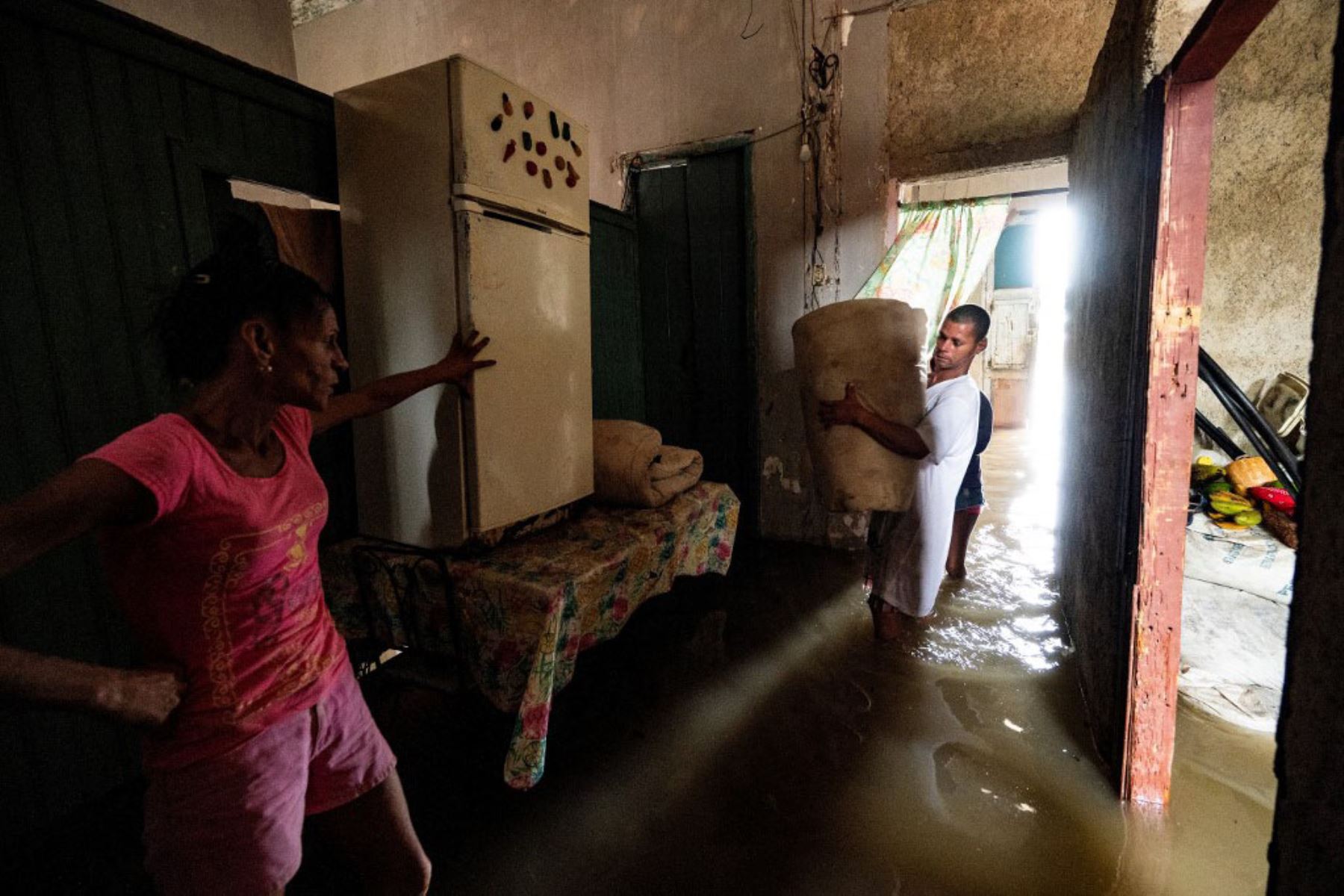 Familia dentro de su casa inundada en Batabano, Cuba, durante el paso del huracán Ian.  Foto: AFP