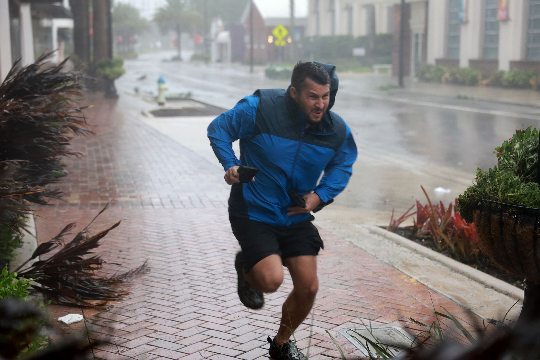 Brent Shaynore corre hacia un lugar protegido a través del viento y la lluvia del huracán Ian  en Sarasota, Florida. Ian tocó tierra esta tarde, con vientos de 150 millas por hora y una marejada ciclónica de 12 pies y dejando sin electricidad a casi 1,5 millones de usuarios.
Foto: AFP