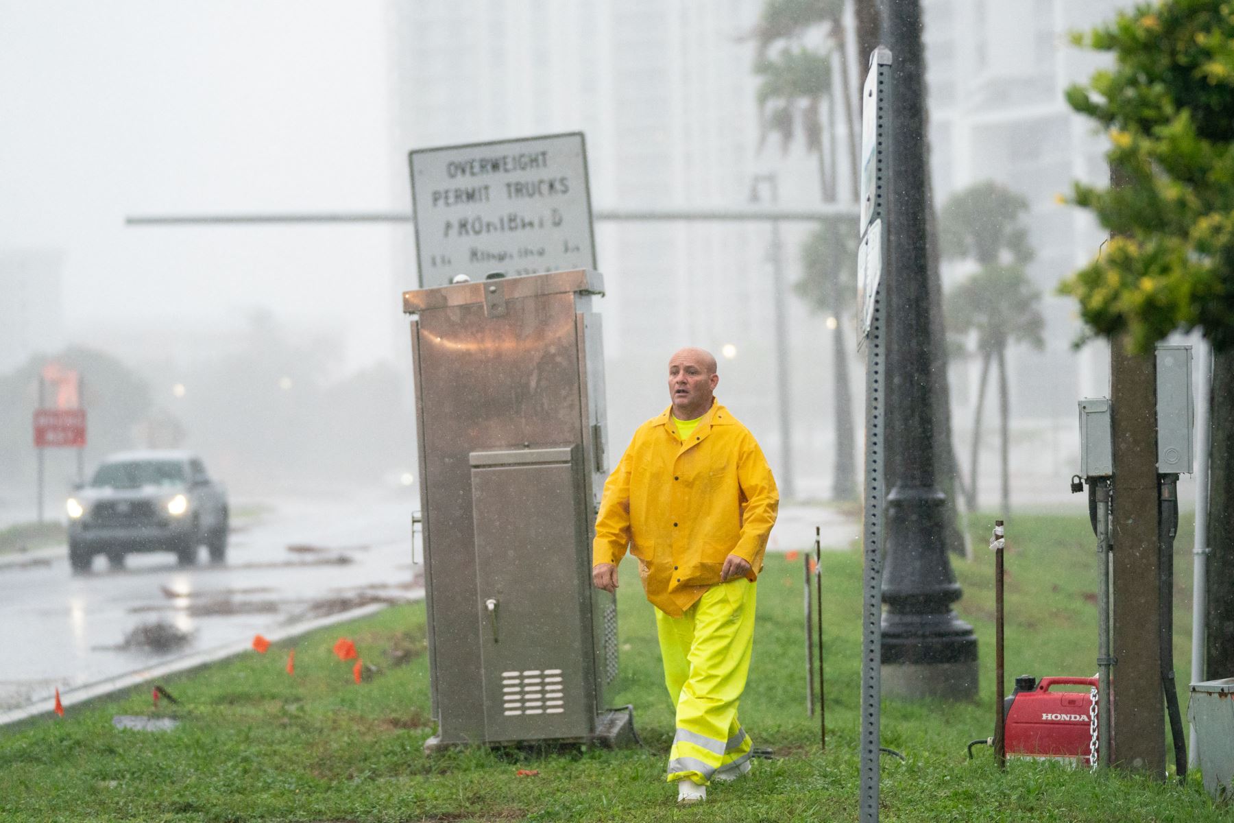 Un trabajador de emergencia despliega un generador para encender una señal de tráfico a medida que se acerca el huracán Ian  en Sarasota, Florida. Ian tocó tierra esta tarde, con vientos de 150 millas por hora y una marejada ciclónica de 12 pies y dejando sin electricidad a casi 1,5 millones de usuarios.
Foto: AFP