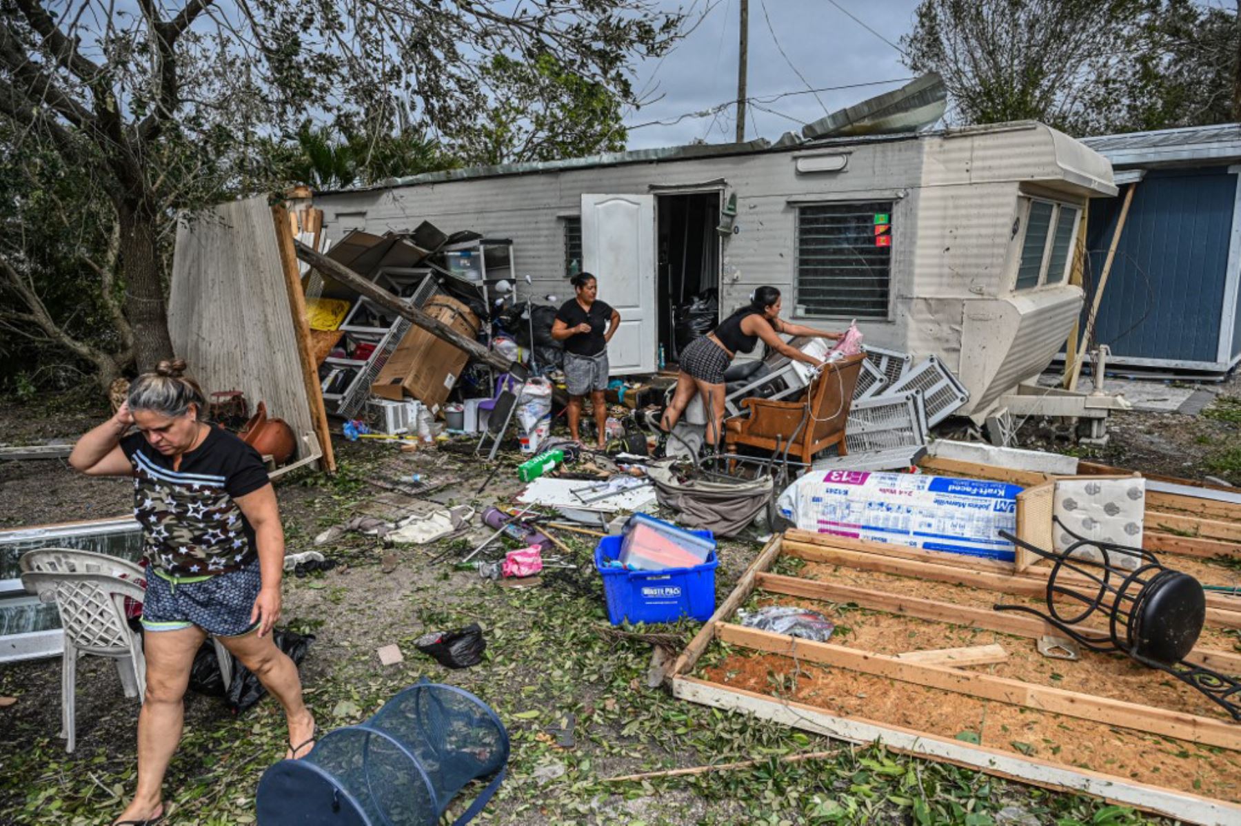 Residentes de casas móviles limpian los escombros después del huracán Ian, en Florida. Foto: AFP