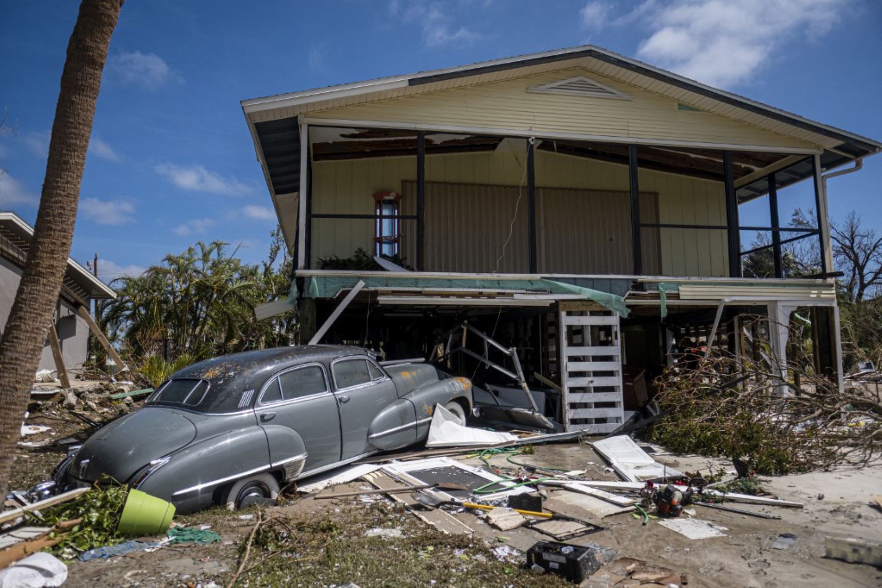 Un viejo auto clásico se sienta frente a una casa después del huracán Ian, en Fort Myers, Florida. Foto: AFP