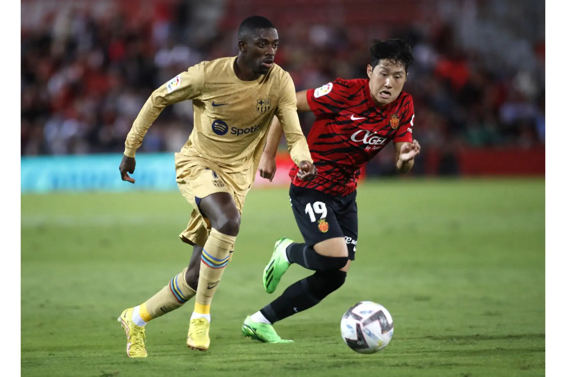 El delantero francés de Barcelona, Ousmane Dembele, compite con el delantero surcoreano de Mallorca Lee Kang-in durante el partido de la Liga española. Foto: AFP