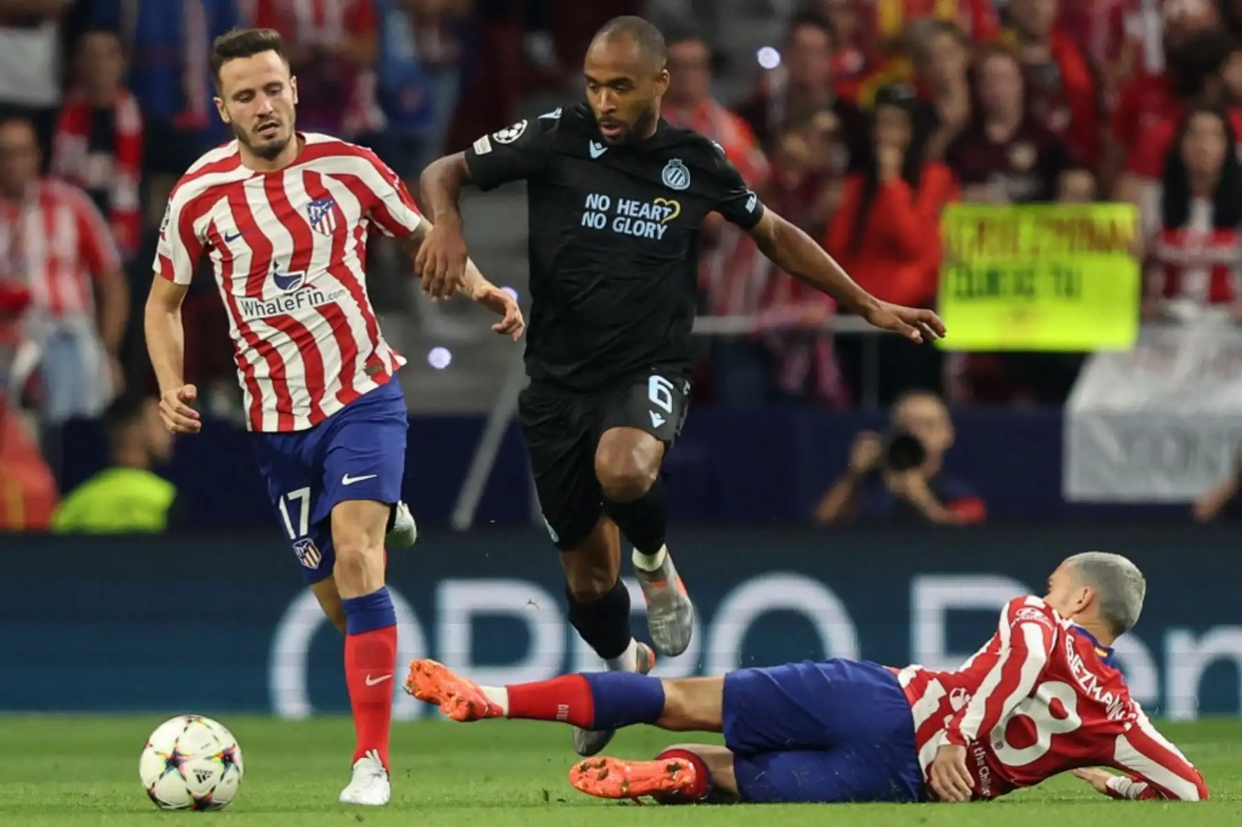 El delantero francés del Atlético de Madrid, Antoine Griezmann, aborda al defensor ghanés del Club Brugge, Denis Odoi , junto al centrocampista español del Atlético de Madrid, Saul Niguez, durante la primera ronda de la Liga de Campeones de la UEFA, grupo B, partido de fútbol entre el Club Atlético de Madrid y el Club Brugge en el Estadio Wanda Metropolitano de Madrid. Foto: AFP