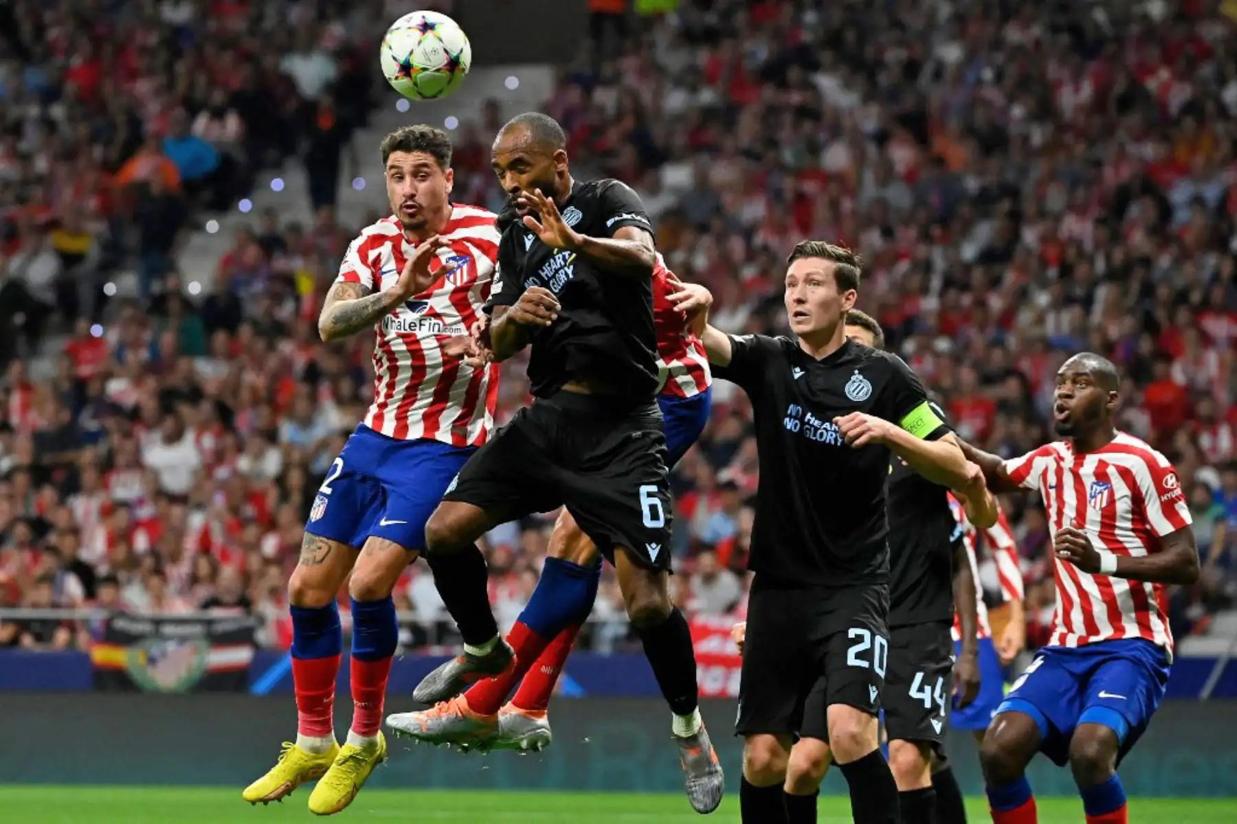 El defensa uruguayo del Atlético de Madrid, José Giménez, y el defensor ghanés del Club Brujas, Denis Odoi, compiten por un cabezazo durante la primera ronda de la Liga de Campeones de la UEFA, grupo B, partido de fútbol entre el Club Atlético de Madrid y el Club Brujas en el estadio Wanda Metropolitano de Madrid. Foto: AFP