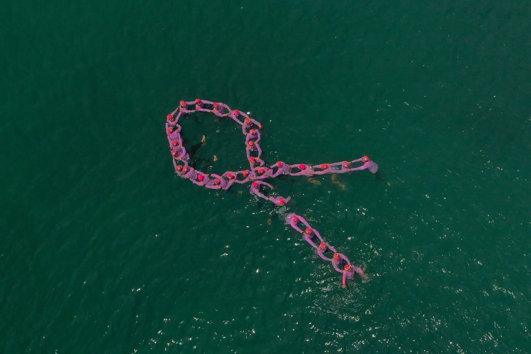Un grupo de mujeres nadadoras, entre las que figuran pacientes que vencieron el cáncer de mama, se sumaron a la campaña preventiva que promueve EsSalud contra ese mal oncológico y formaron un lazo de color rosa en el mar de la playa Agua Dulce, en Chorrillos. Foto: EsSalud