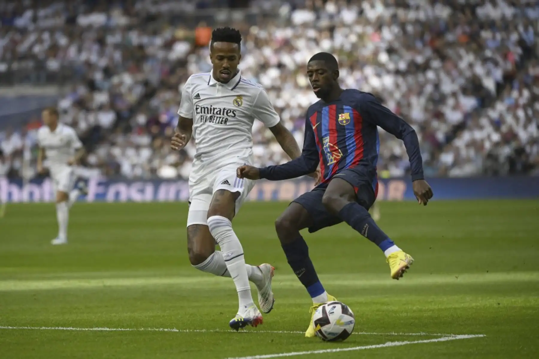 El defensa brasileño del Real Madrid, Eder Militao, compite con el delantero francés del Barcelona, ​​Ousmane Dembele (D), durante el partido de fútbol de la Liga española entre el Real Madrid CF y el FC Barcelona en el estadio Santiago Bernabeu.

Foto: AFP